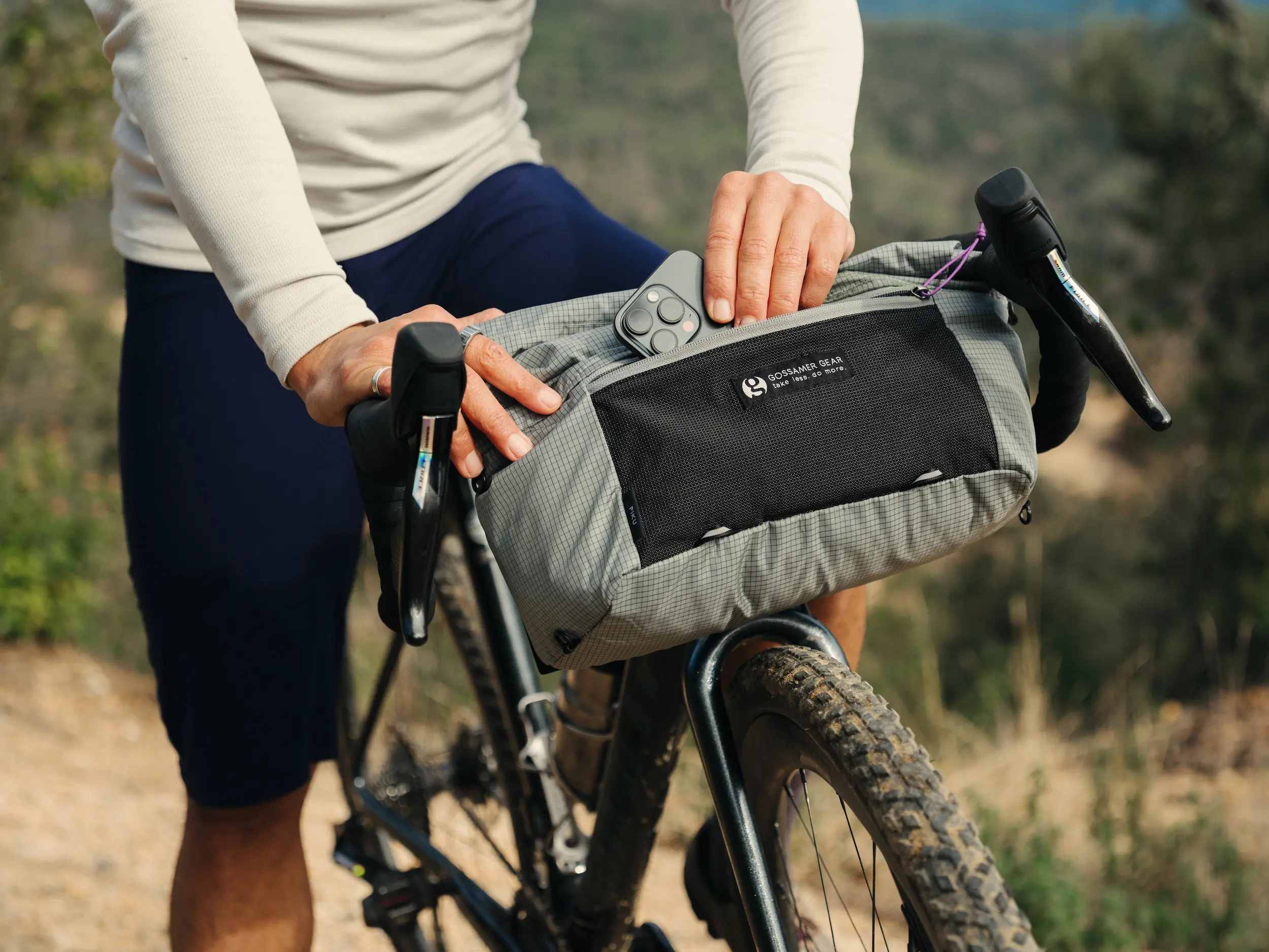 Day pack on front of bike, person putting phone into pack