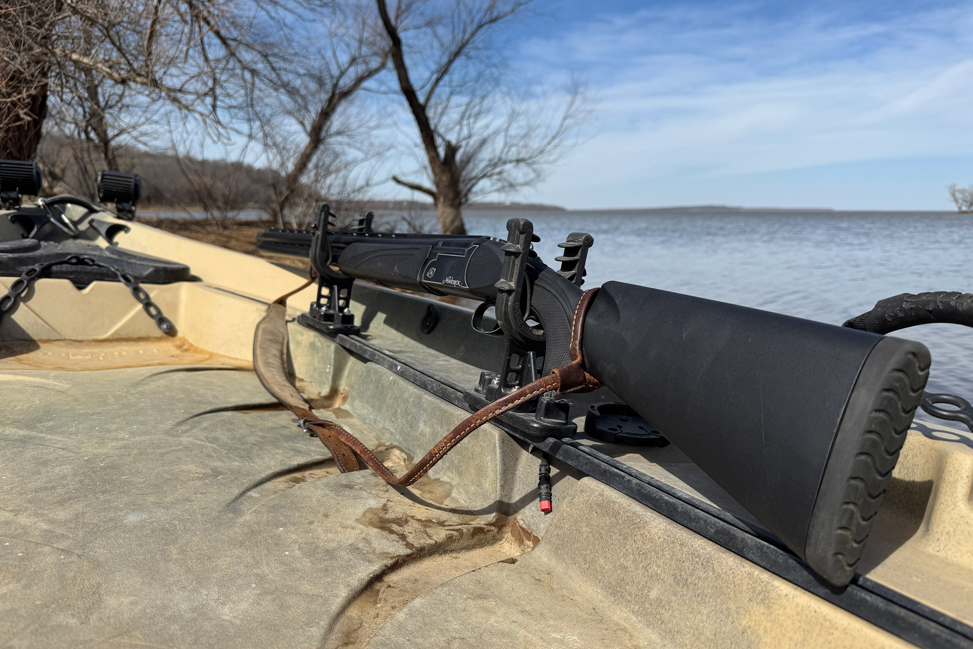 A turkey hunting gun is securely placed on the kayak's mount