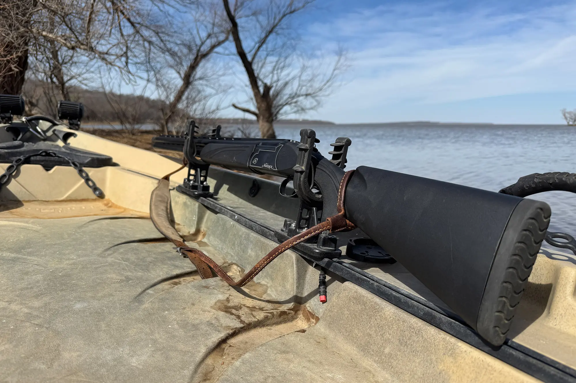 A turkey hunting gun is securely placed on the kayak's mount