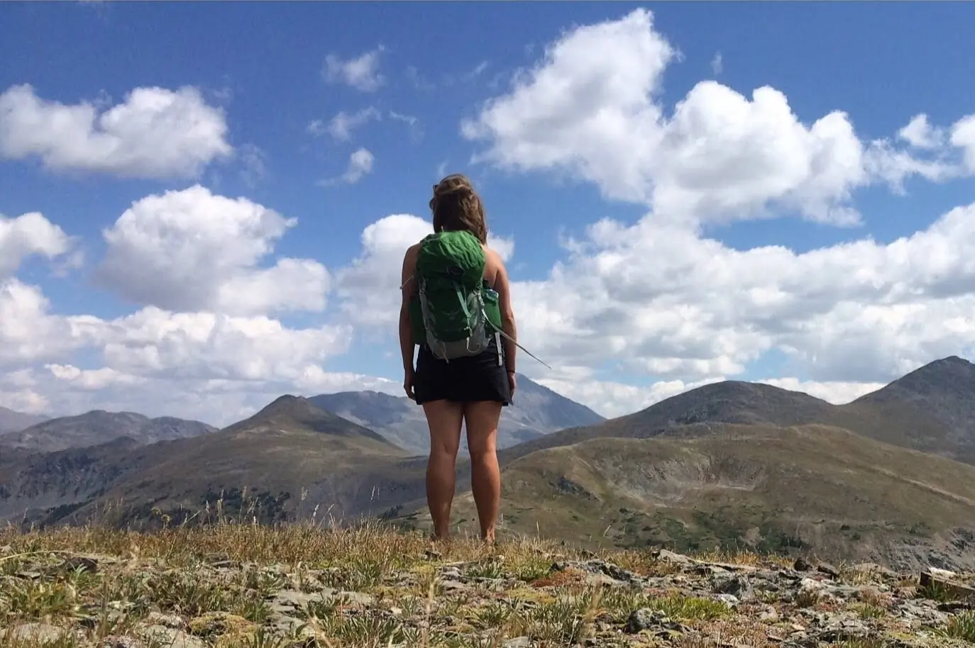 Hiker in skirt in front of mountains
