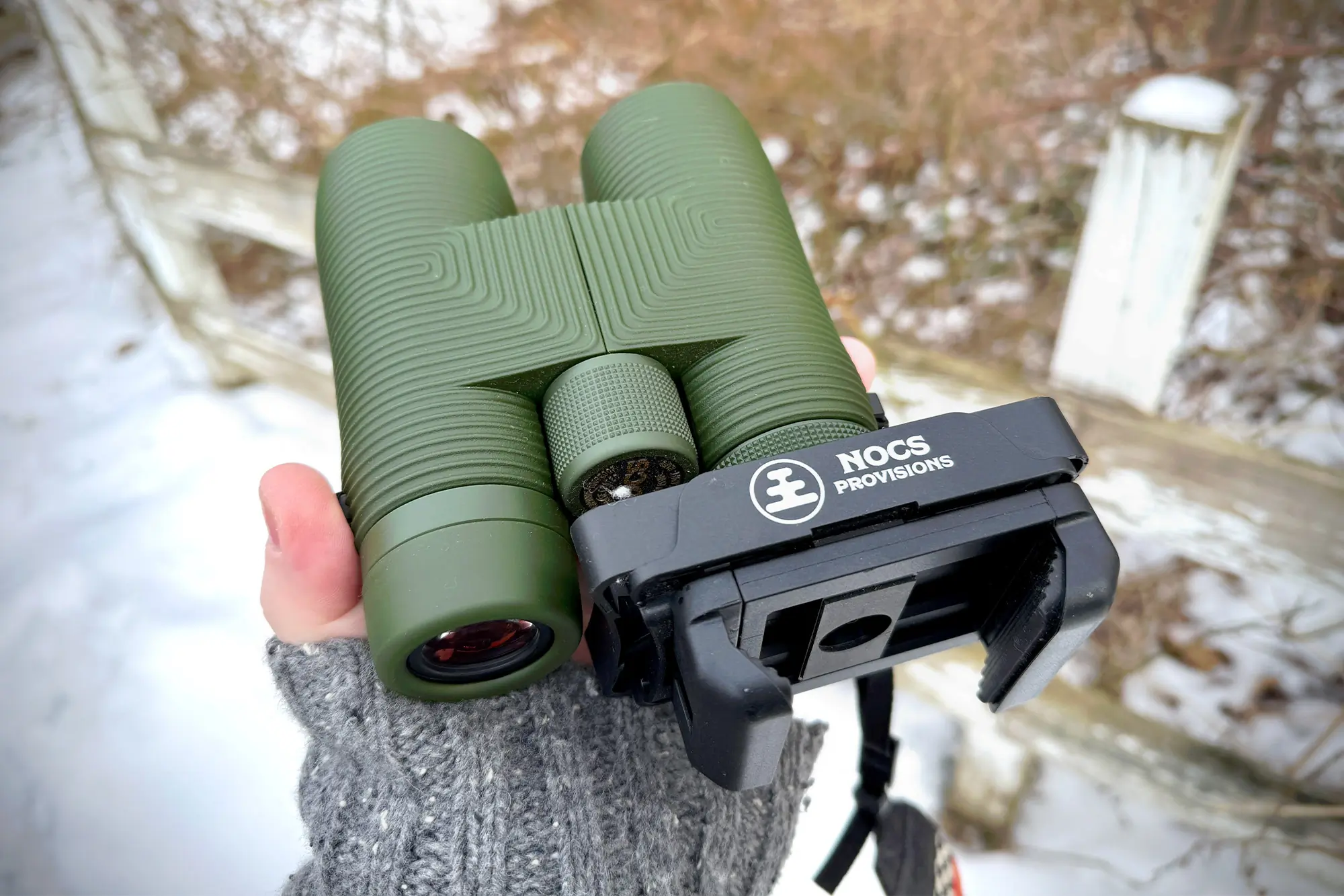 Nocs Pro Issue 8x42 held in hand with a phone adapter attached, ready for digiscoping