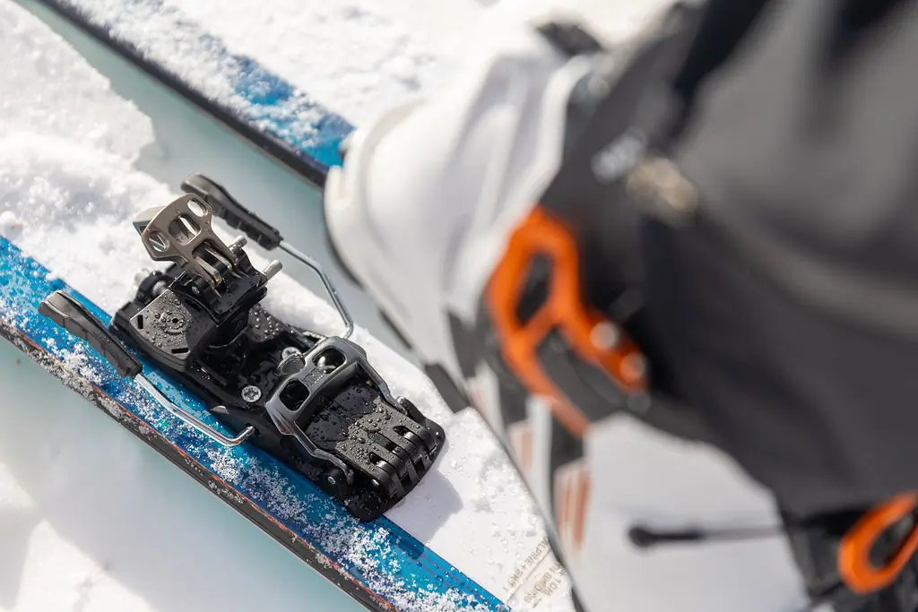 A skier steps into the Salomon MTN Pure bindings in the snow