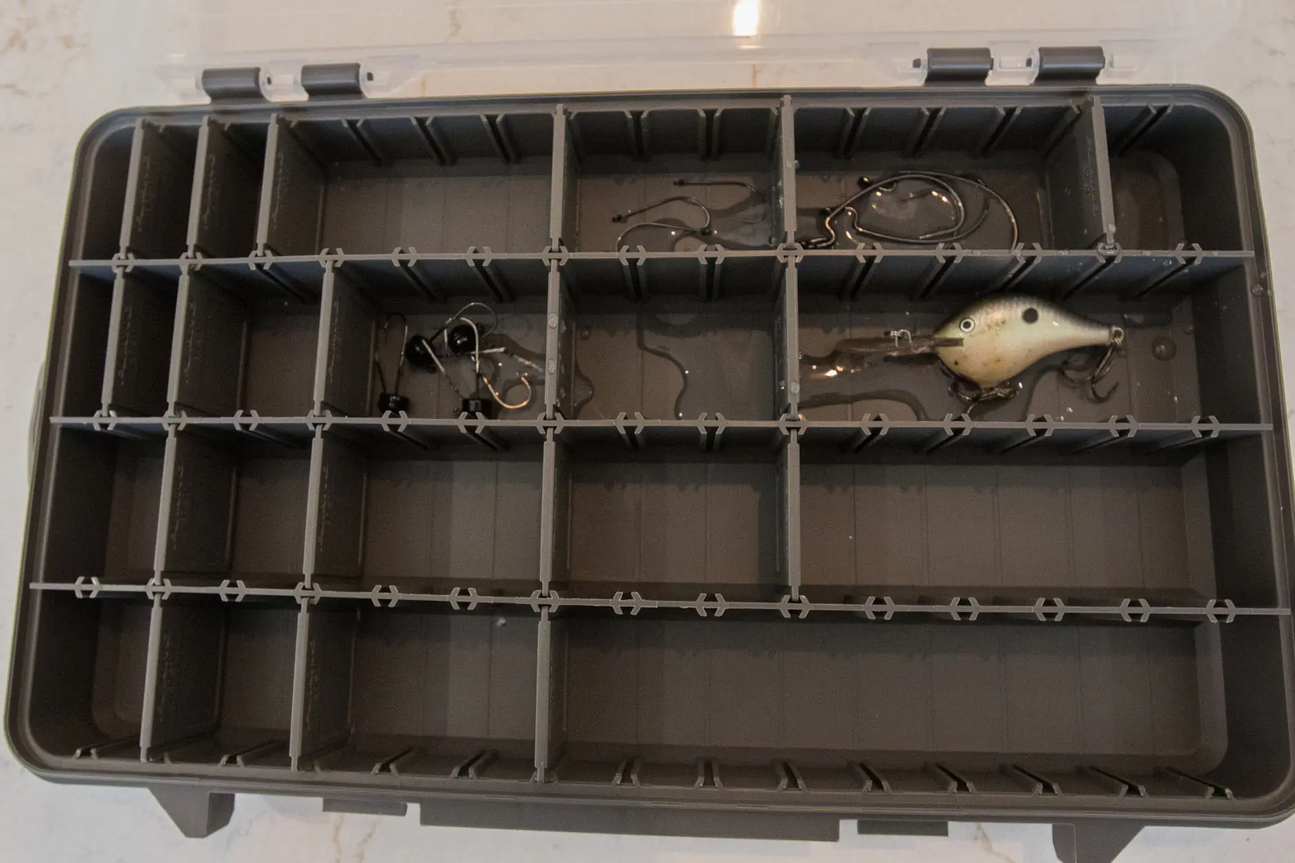 A Plano StowAway Tackle box with water and hooks in it to test rust inhibitor.