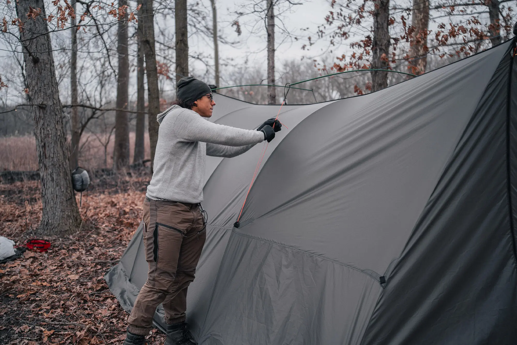 Camper tightens a guyline to elevate the Warbonnet Tsunami’s midsection