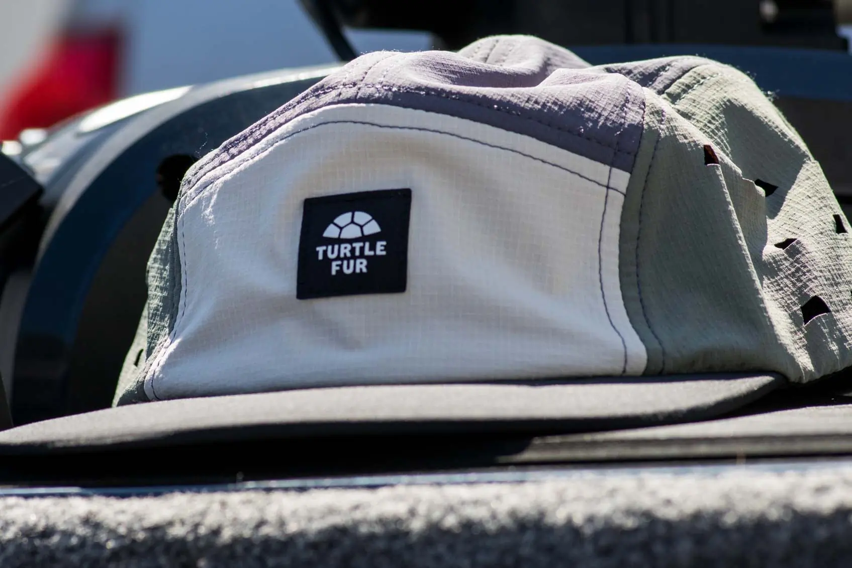 Turtle Fur Way Out 5 Panel Hat sitting on a boat deck