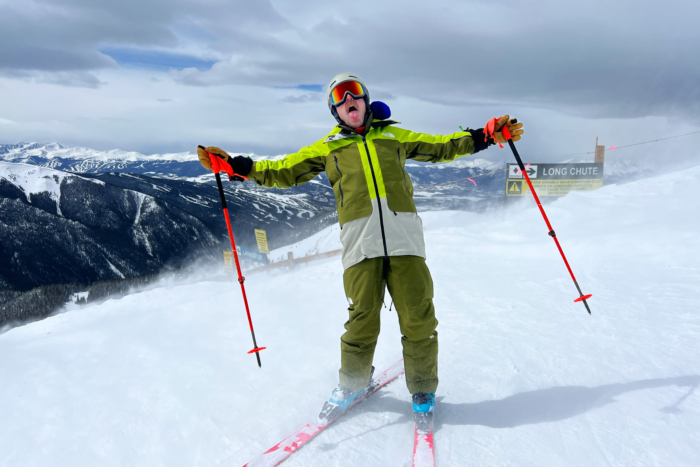 Man blown by wind on ski hill wearing The North Face Verbier jacket