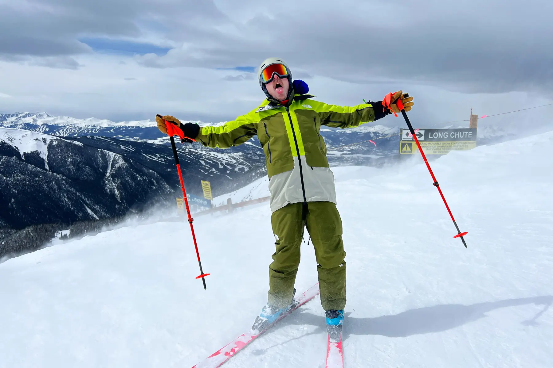 Man blown by wind on ski hill wearing The North Face Verbier jacket