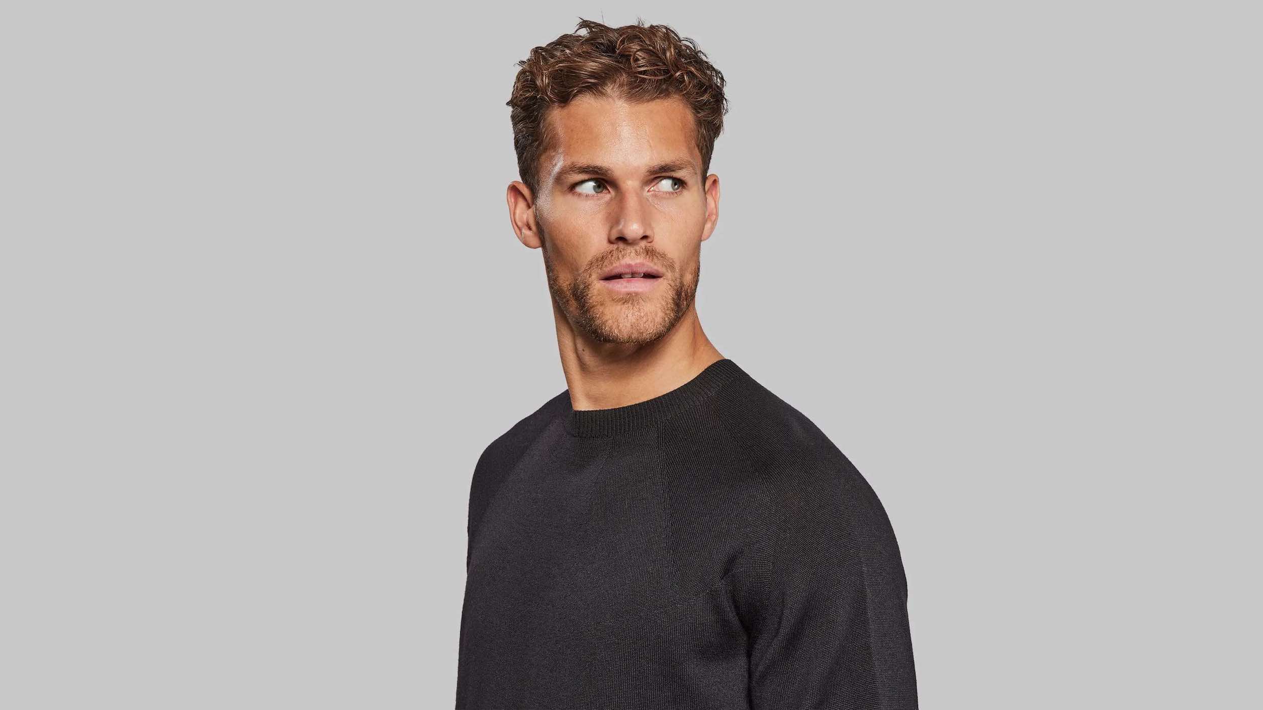 Man wearing black sweater facing camera