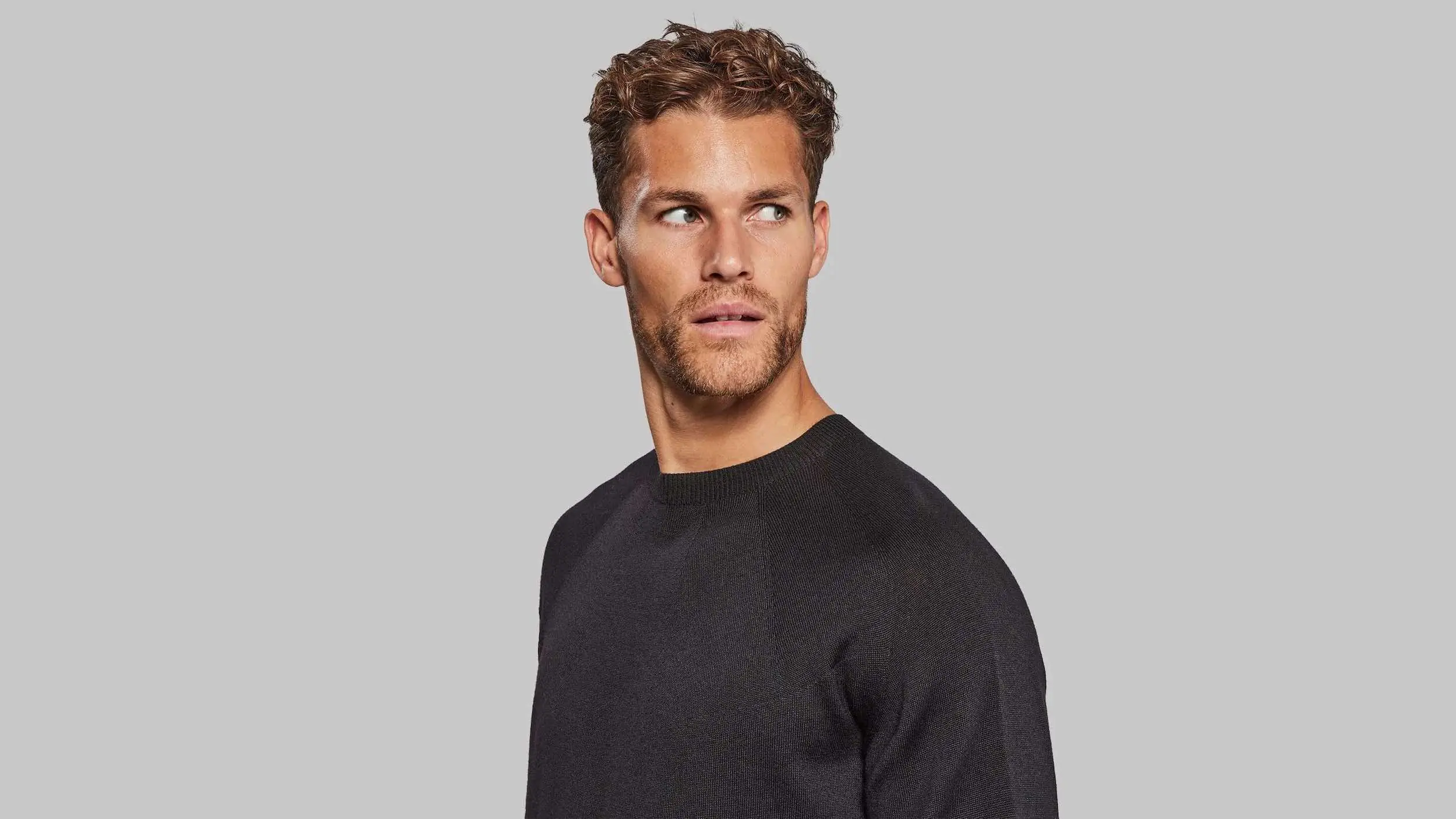 Man wearing black sweater facing camera