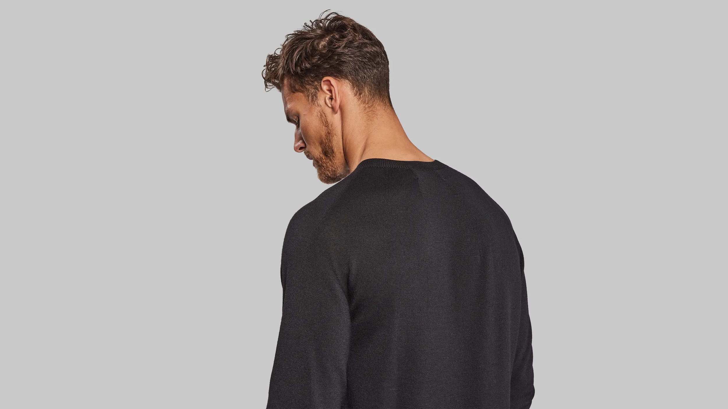 Man wearing black sweater facing away from camera