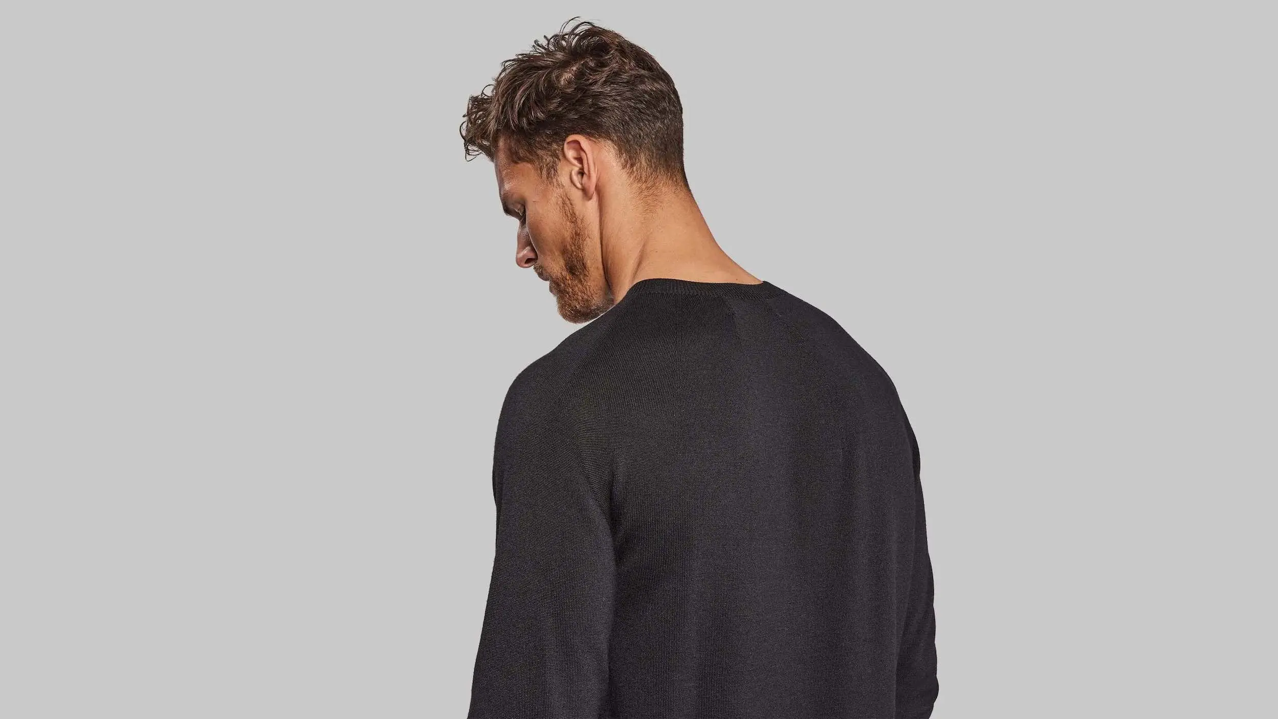 Man wearing black sweater facing away from camera