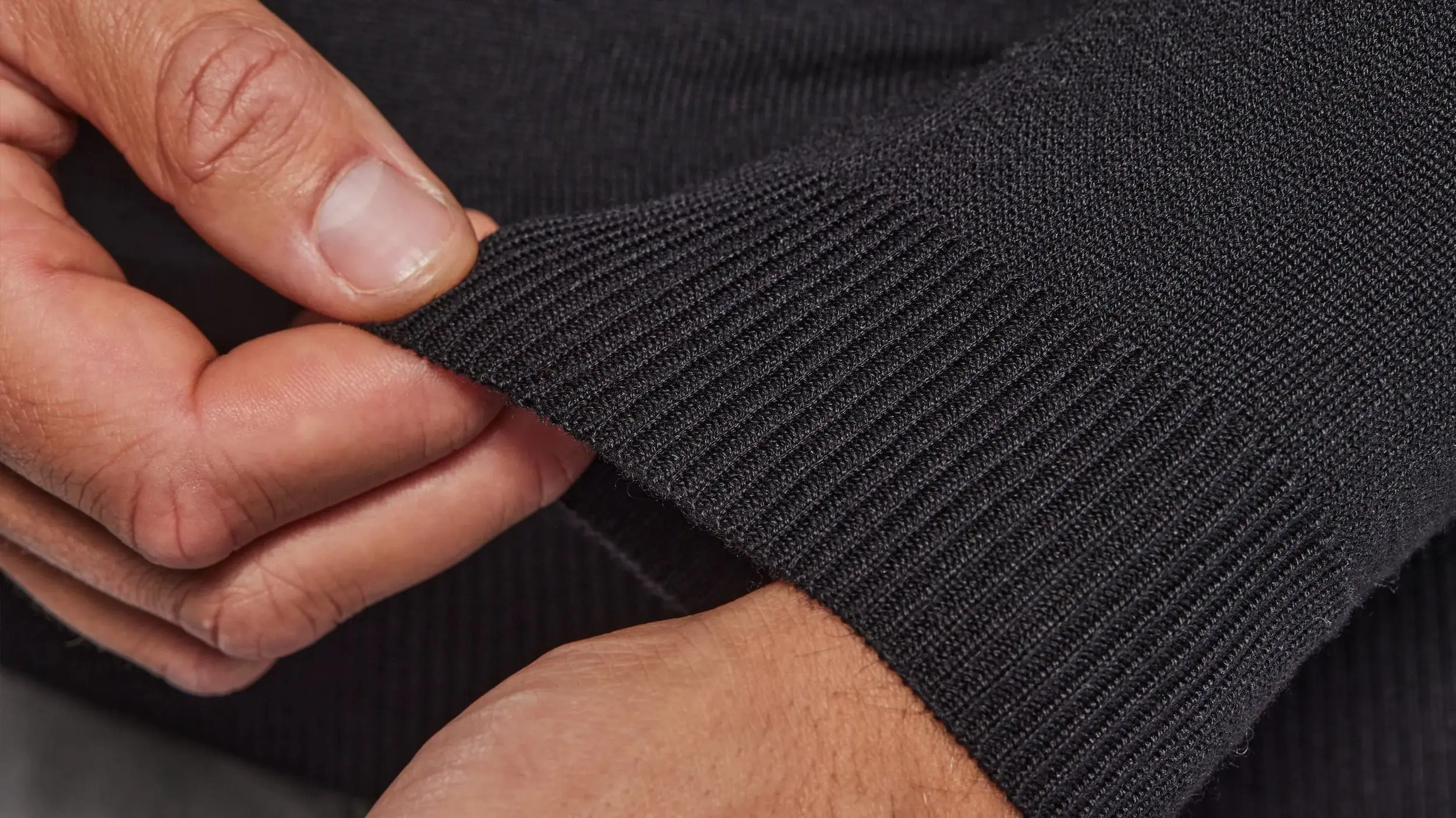 Hands showing cuff of black sweater