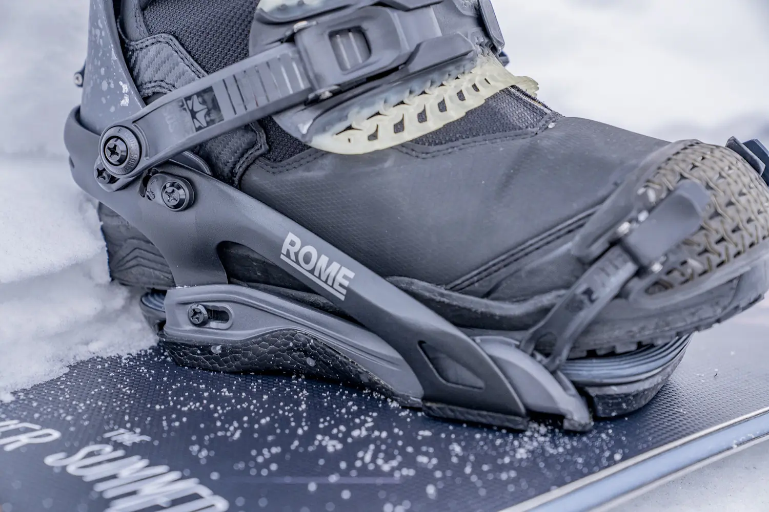 Close-up of a Rome Katana Pro snowboard binding secured to a boot, showing the baseplate