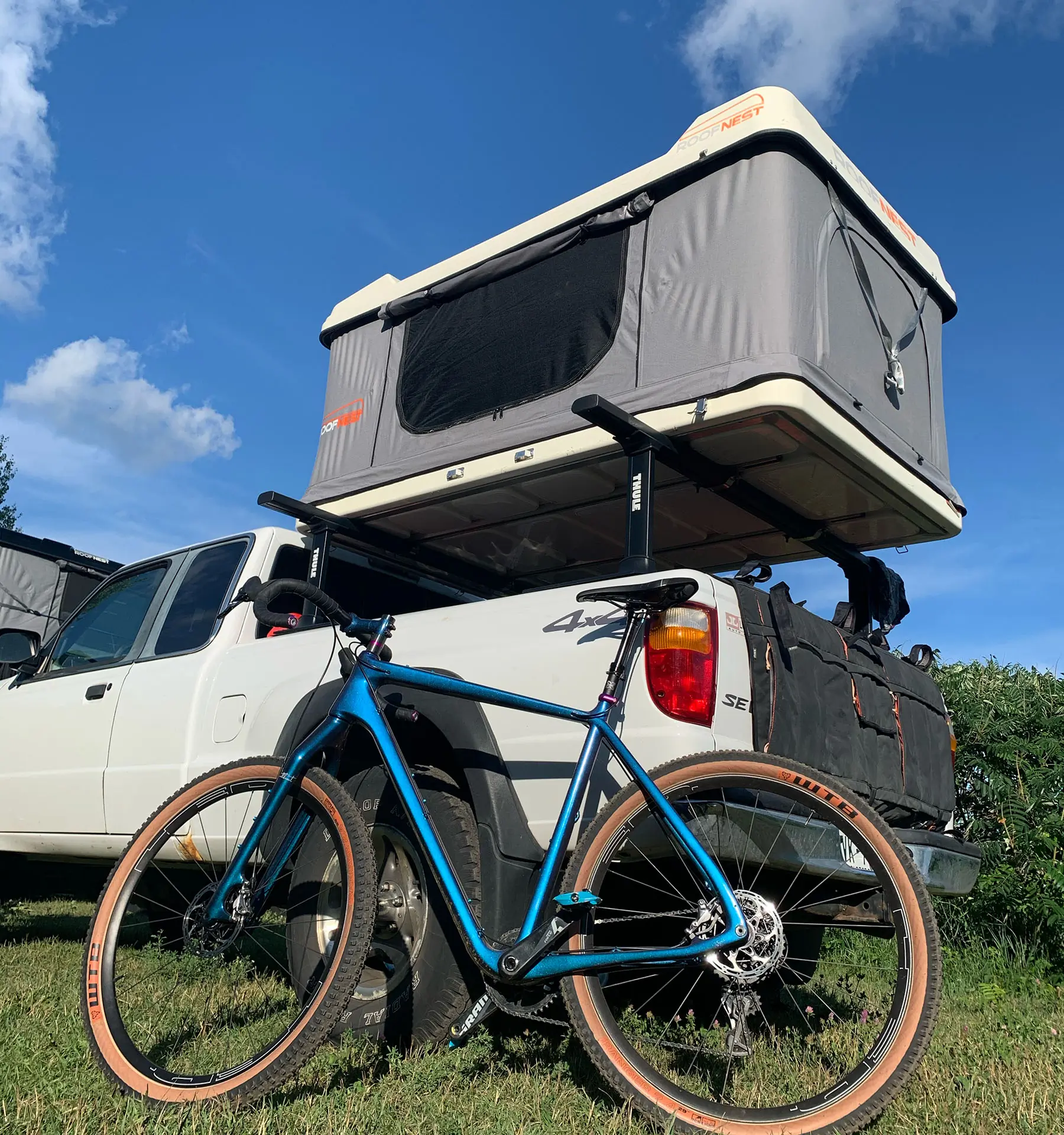 mountain bike next to truck with roof top tent