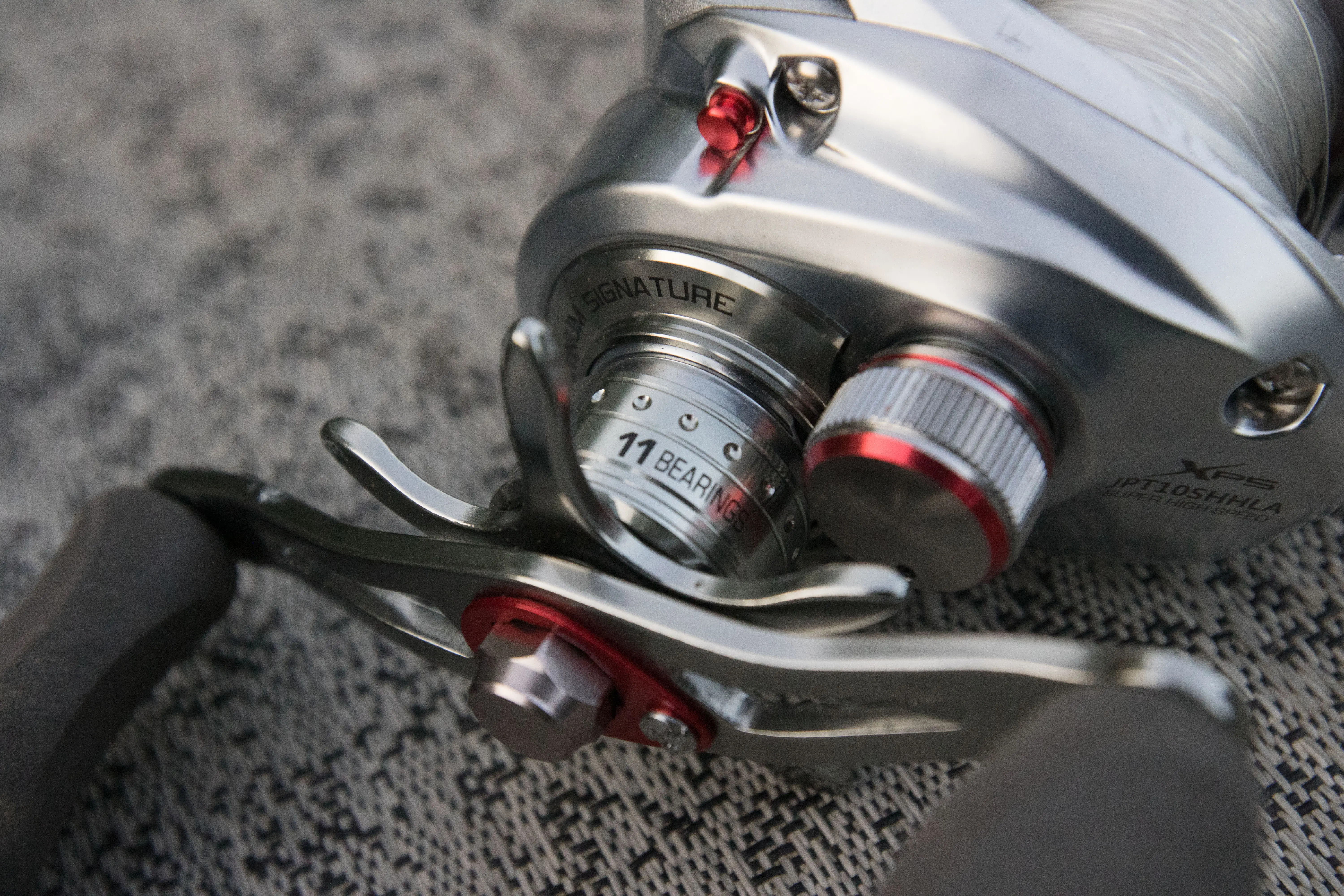The reel handle and specs displayed on the Johnny Morris Platinum Signature baitcaser