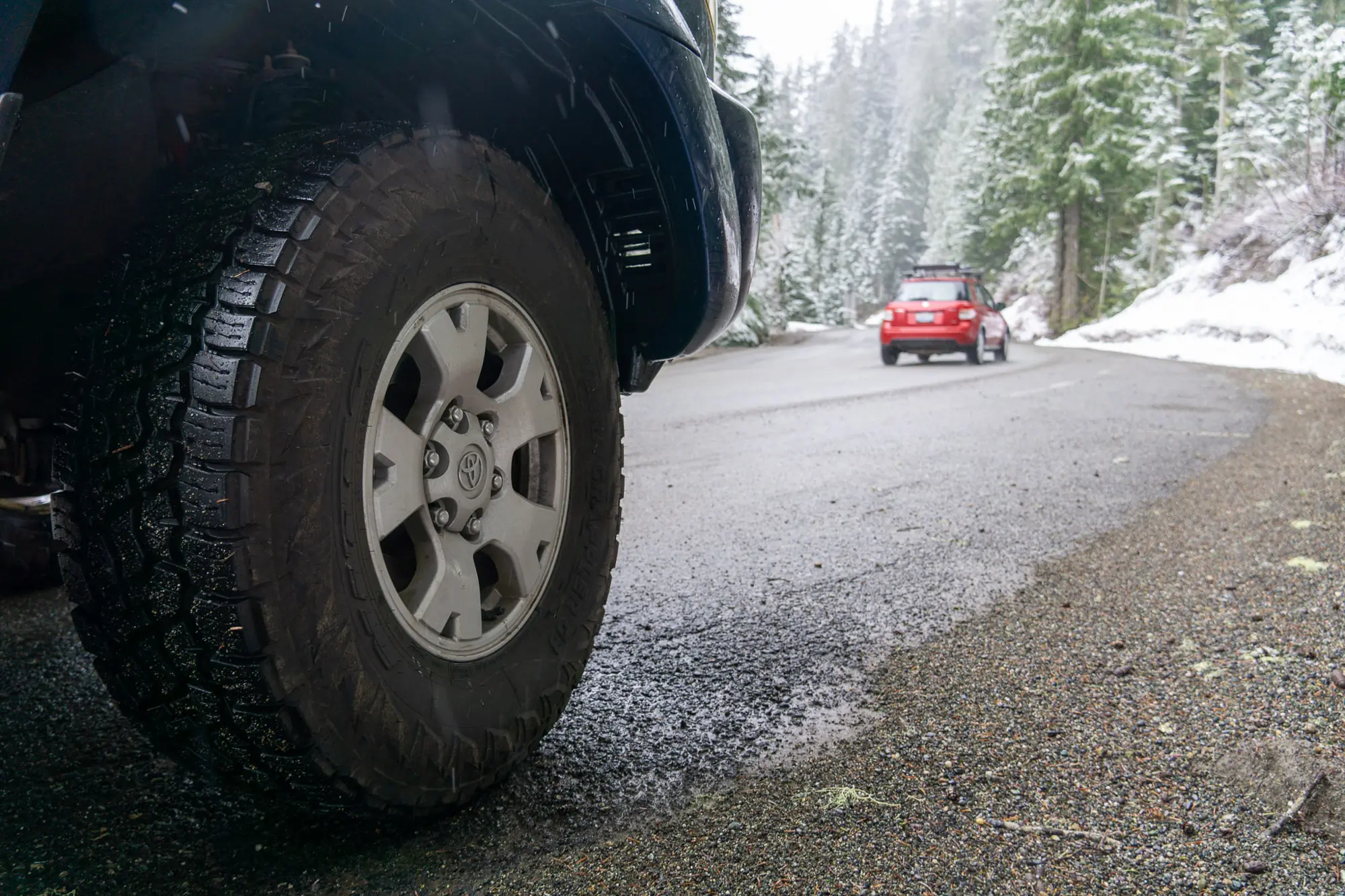 A truck pulled over to the side of the snowy road detailing the tire tread