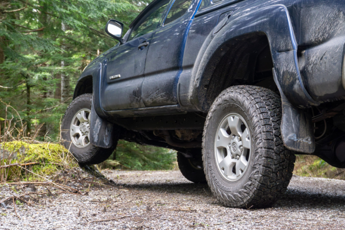 A Toyota Tacoma running Nitto Terra Grappler G3 tires flexes on a road-side rock