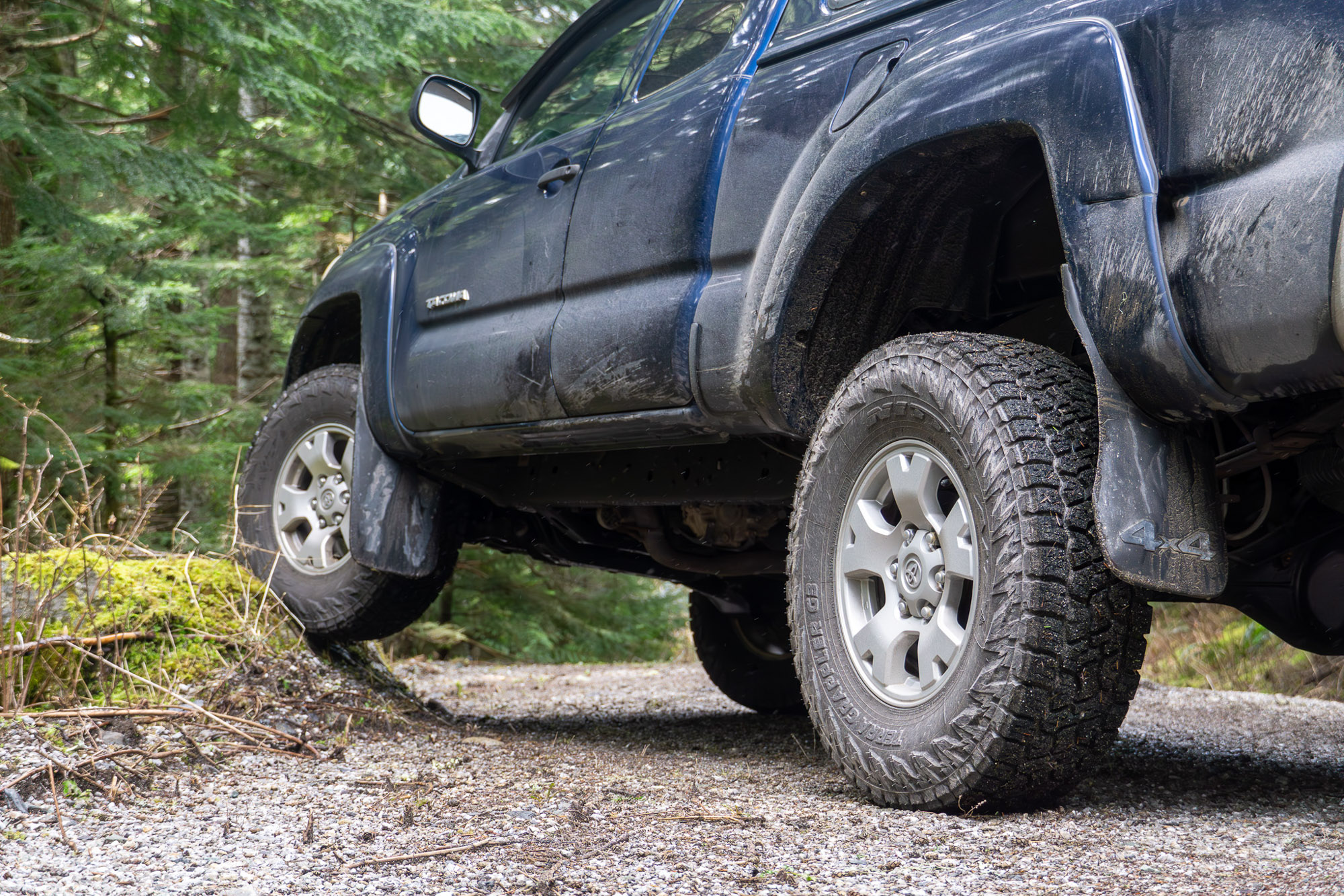 A Toyota Tacoma running Nitto Terra Grappler G3 tires flexes on a road-side rock