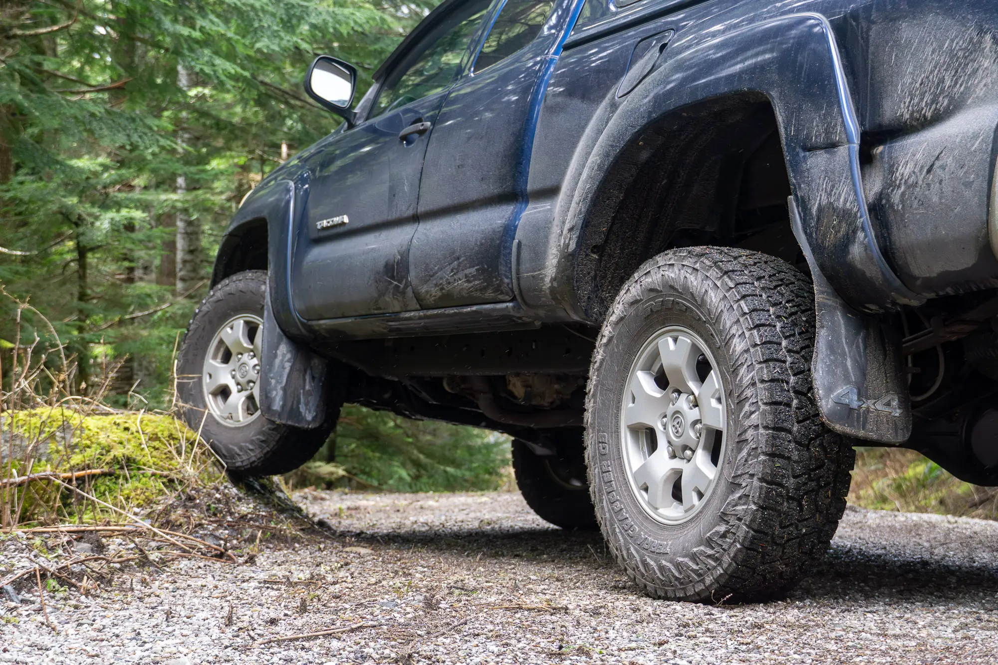 A Toyota Tacoma running Nitto Terra Grappler G3 tires flexes on a road-side rock