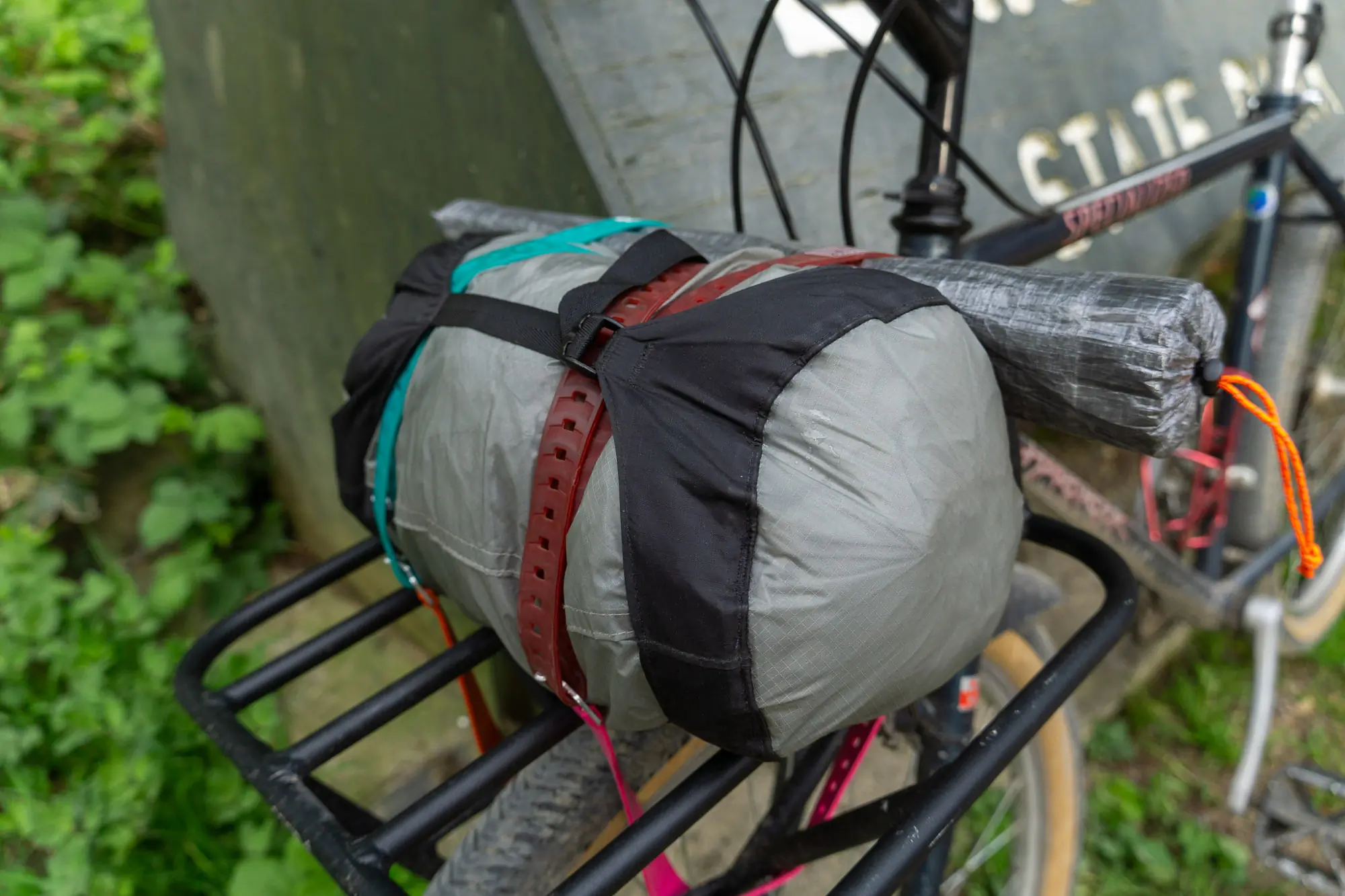 The HMG CrossPeak 2 tent packed in a stuffsack with poles on a bike fron track