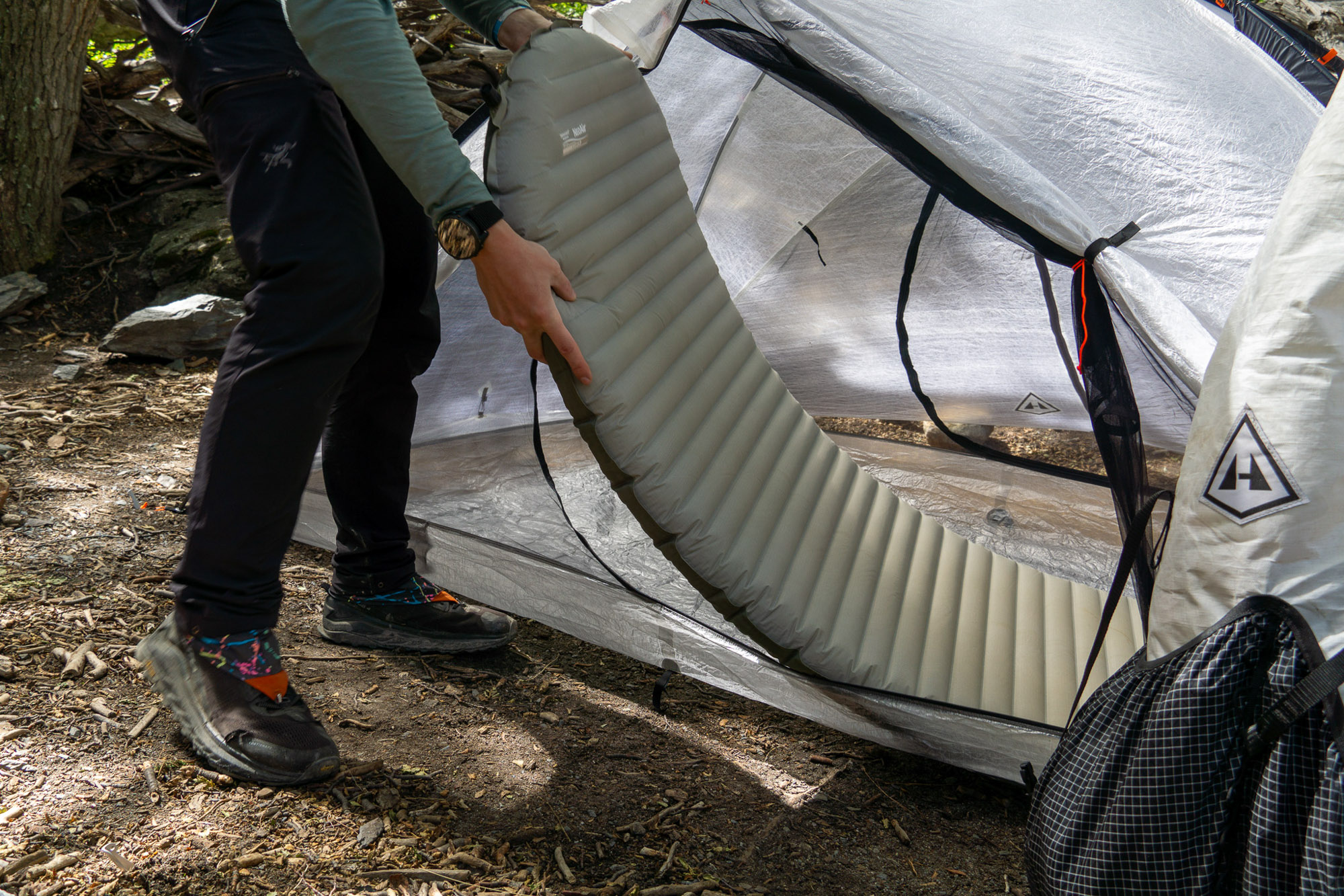 Hiker slides in a sleeping pad into a Dyneema Composite Fiber tent