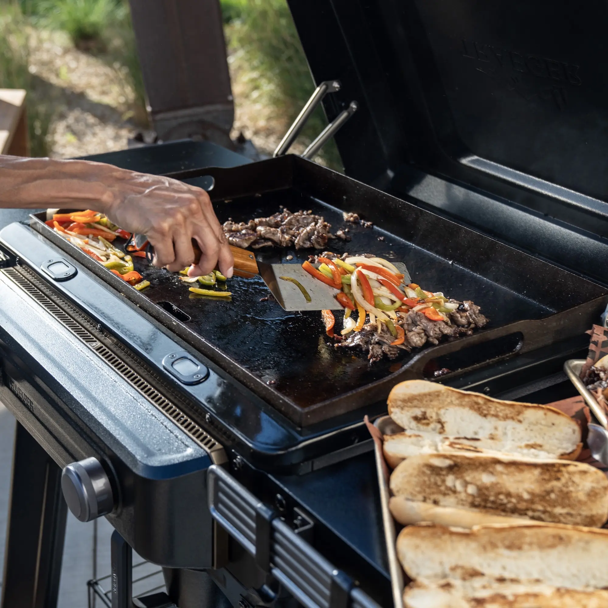 grilling veggies, bread, and meet on a flat top grill