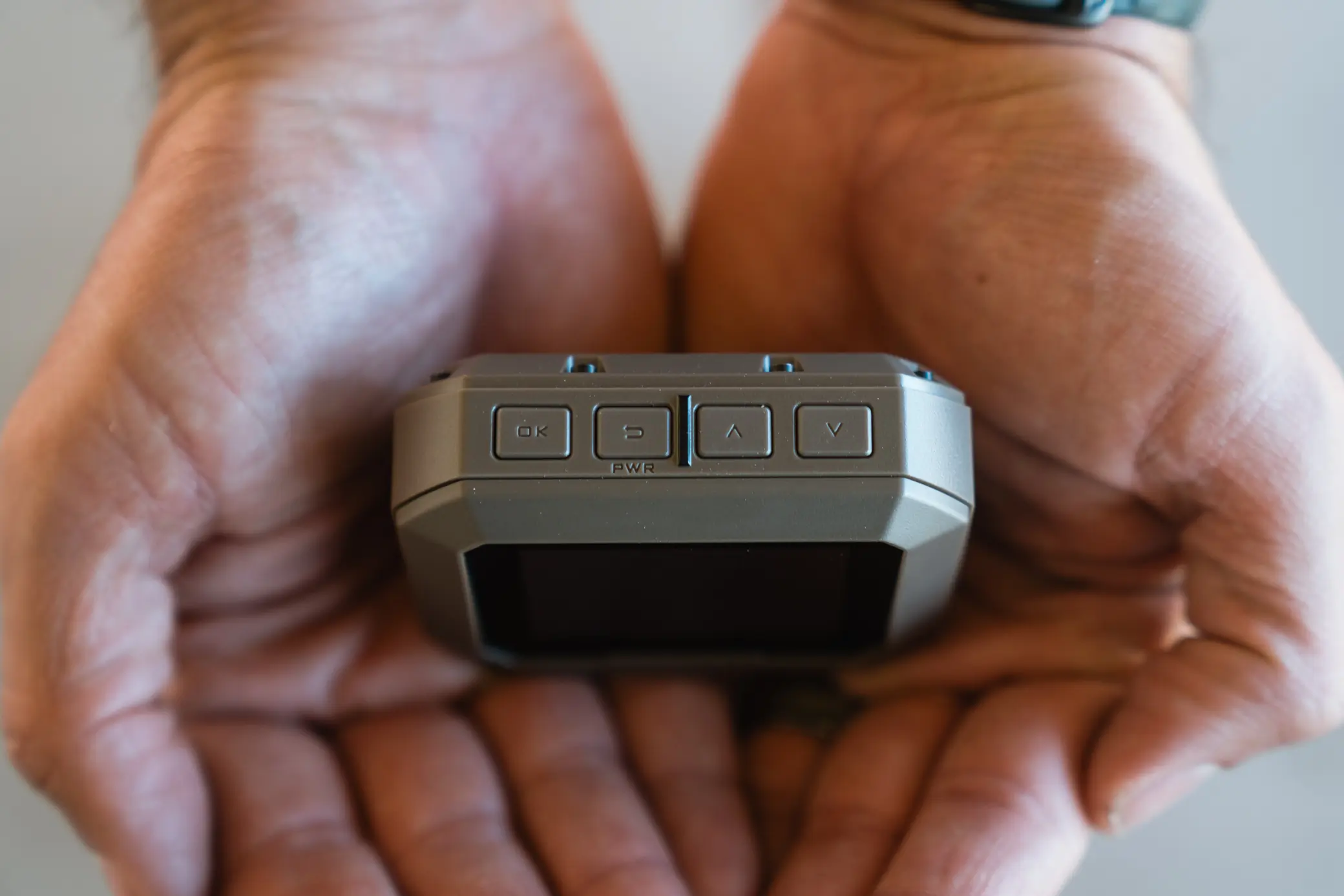 person holding Garmin Xero C1 Pro in palm of the hands - close up