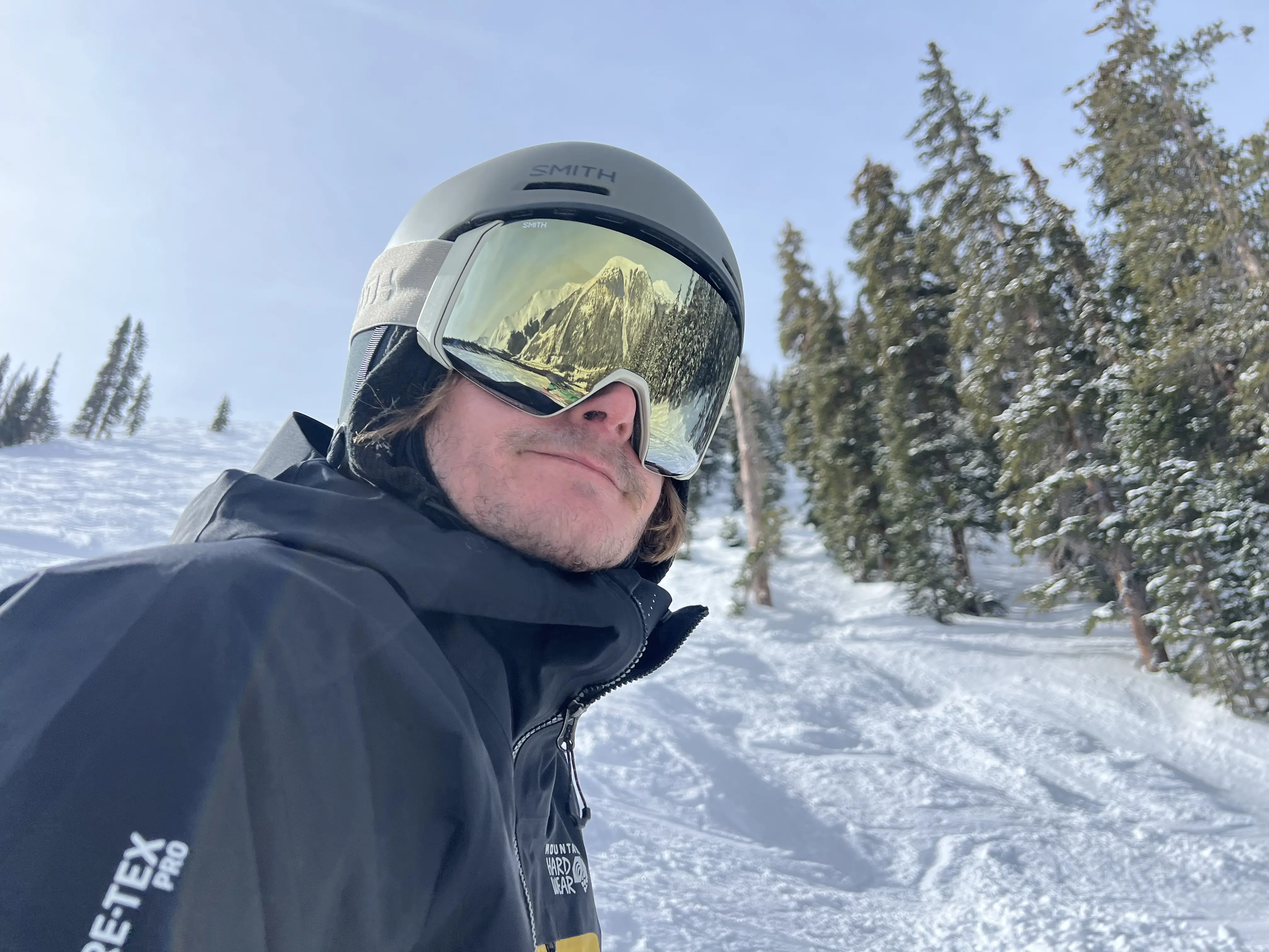 Man wears Smith helmet and goggles on a ski slope