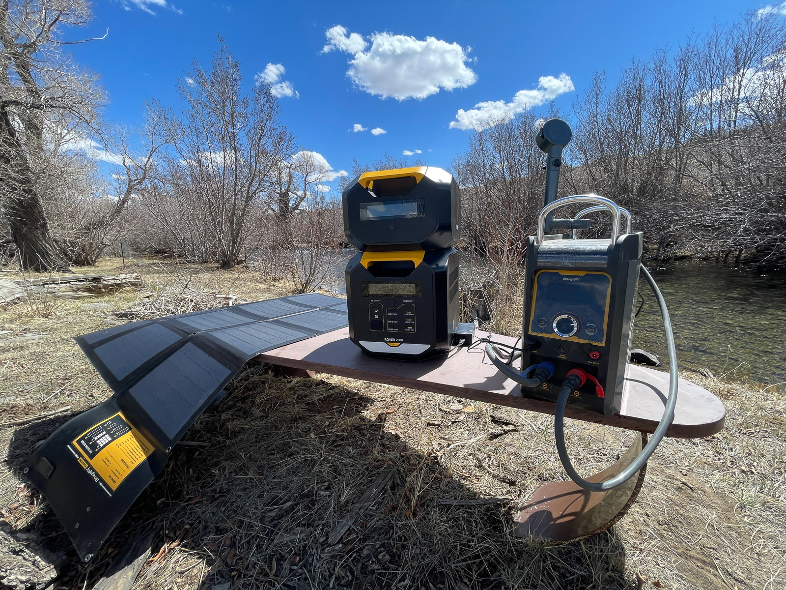 The power station powering a portable hot water shower while charging from the sun