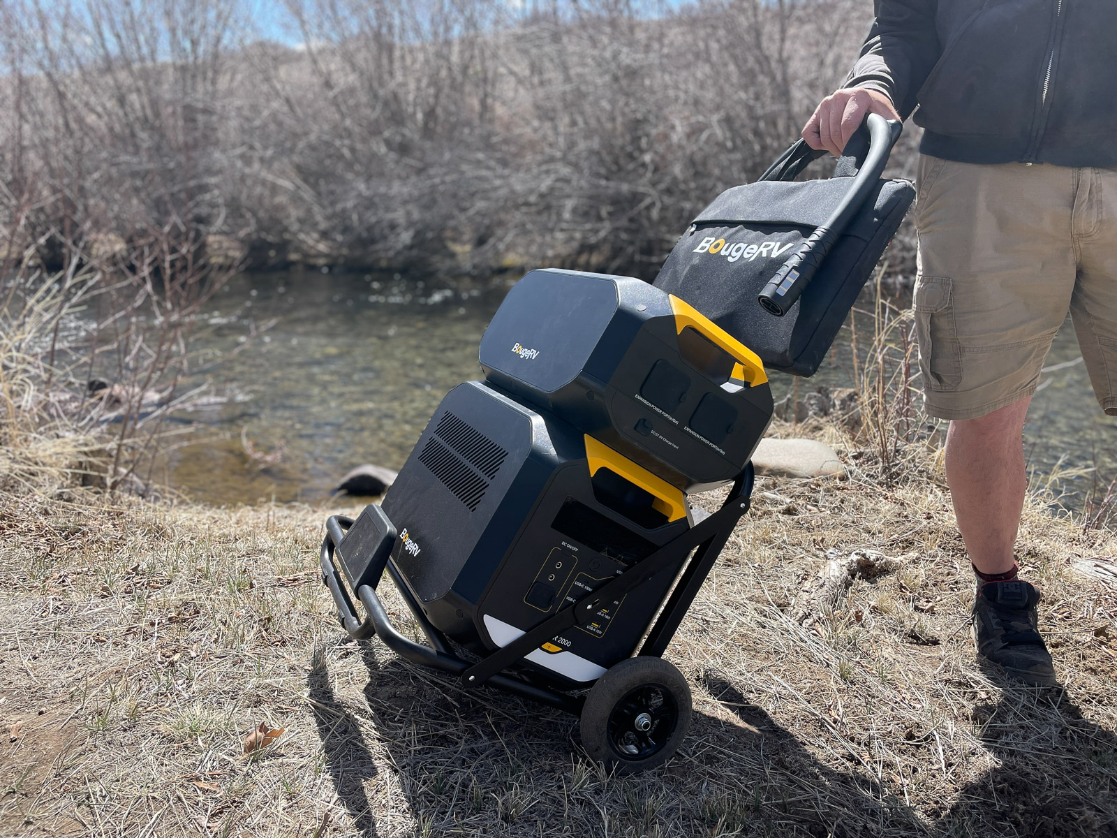 the entire bougerv rover2000 power station, expansion battery, and solar panel packed up and carried on the travel cart