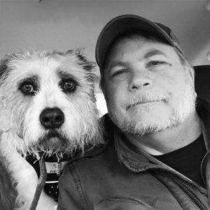 man sitting next to dog