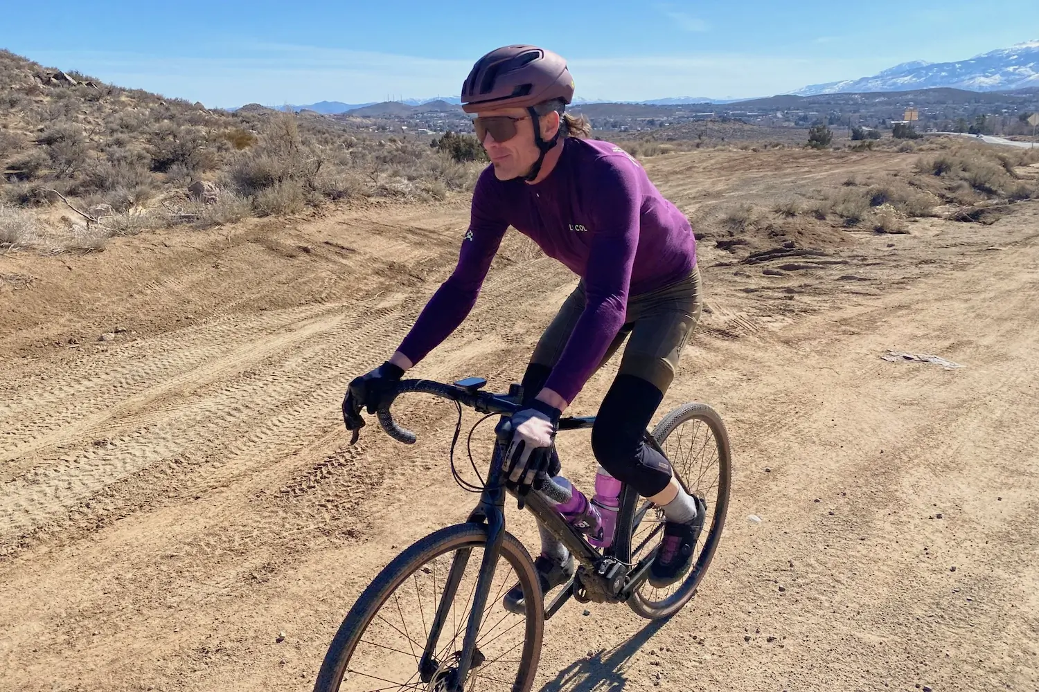 Riding up a gravel road while testing the Le Col ARC bibs and jersey