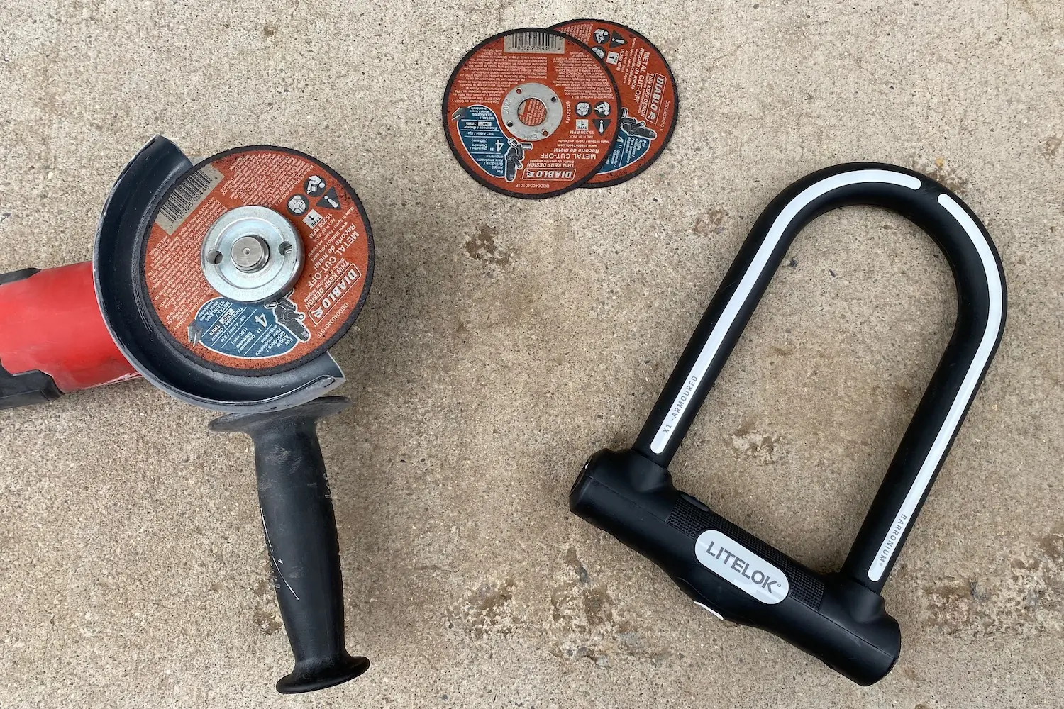 The angle grinder and extra cutoff wheels next to the Litelok X1