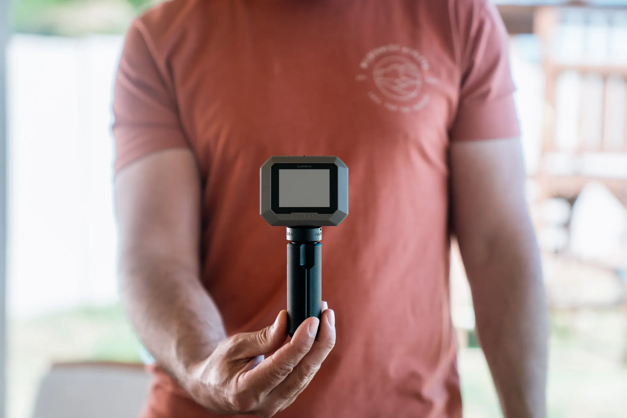 man holding Garmin Xero C1 Pro