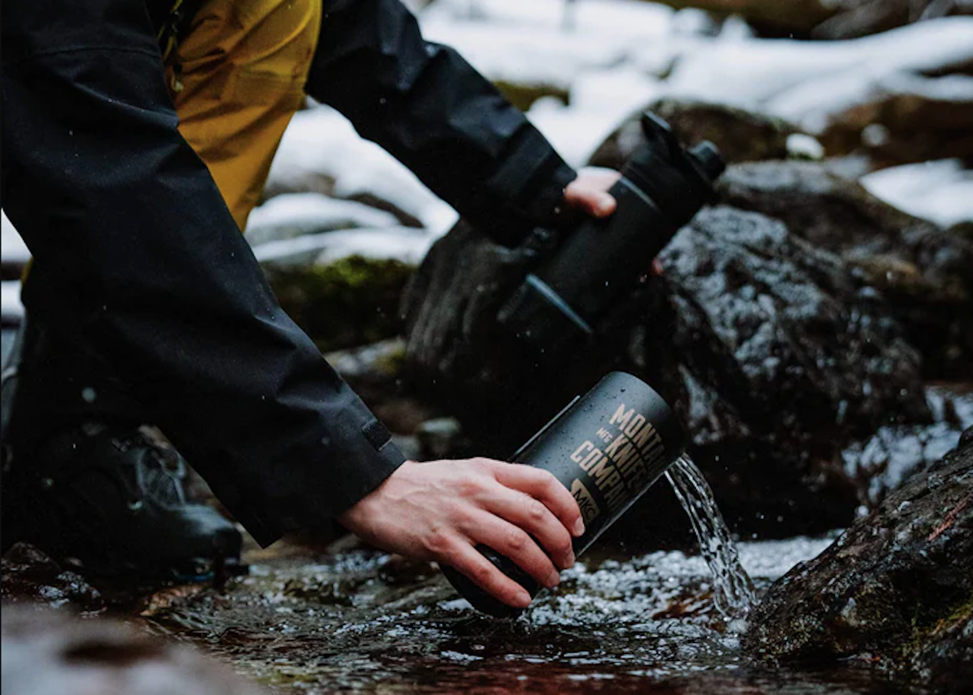 Collecting water from stream in water bottle