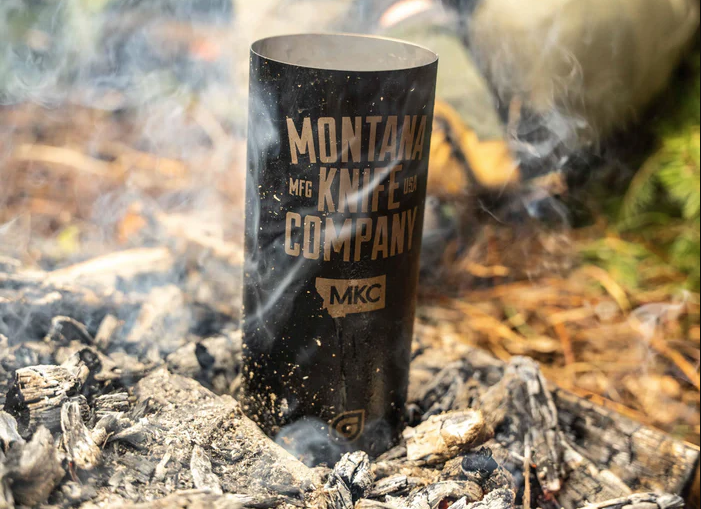 Metal water bottle in ashes of campfire