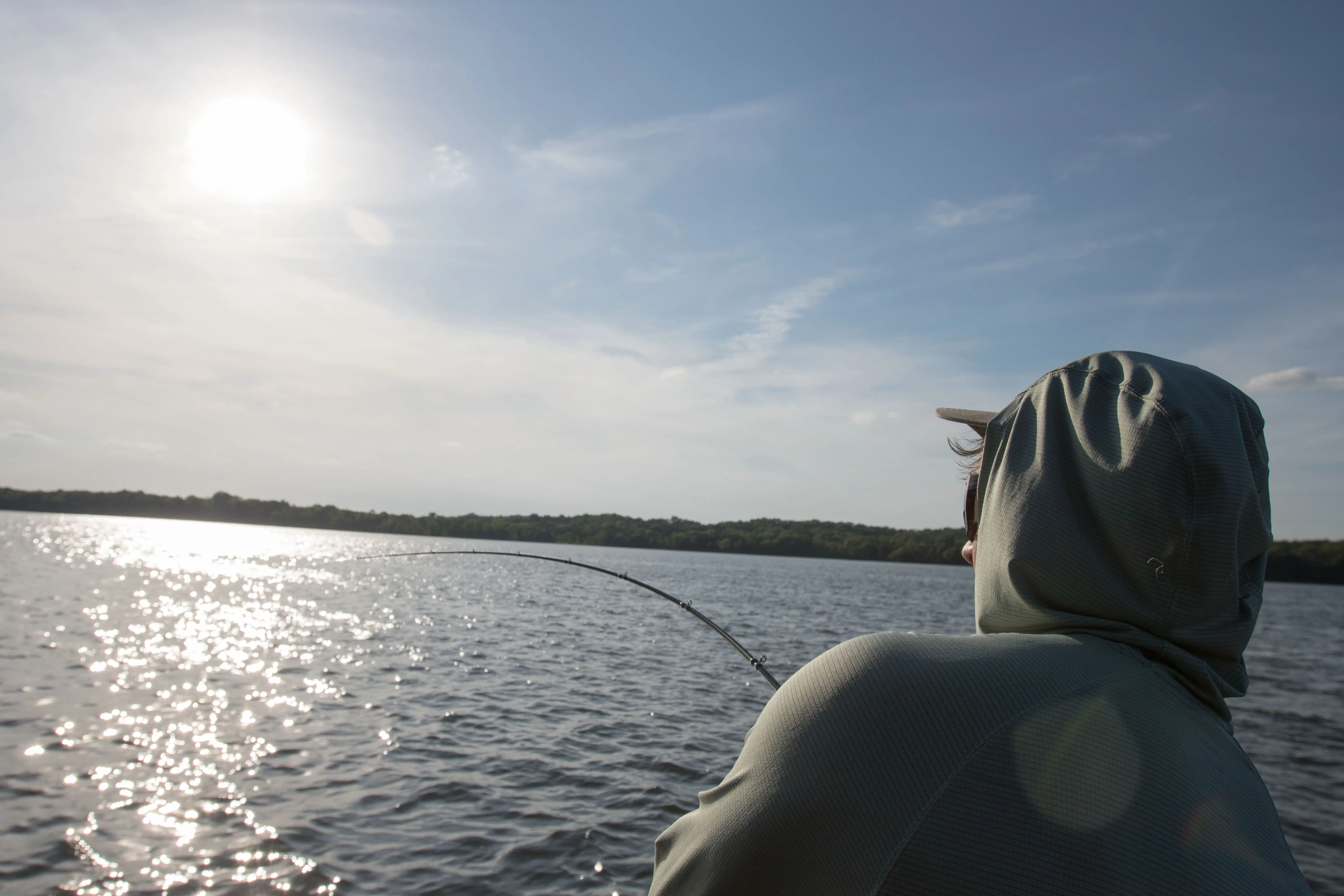 An angler landing a fish with one of the best bass fishing rods