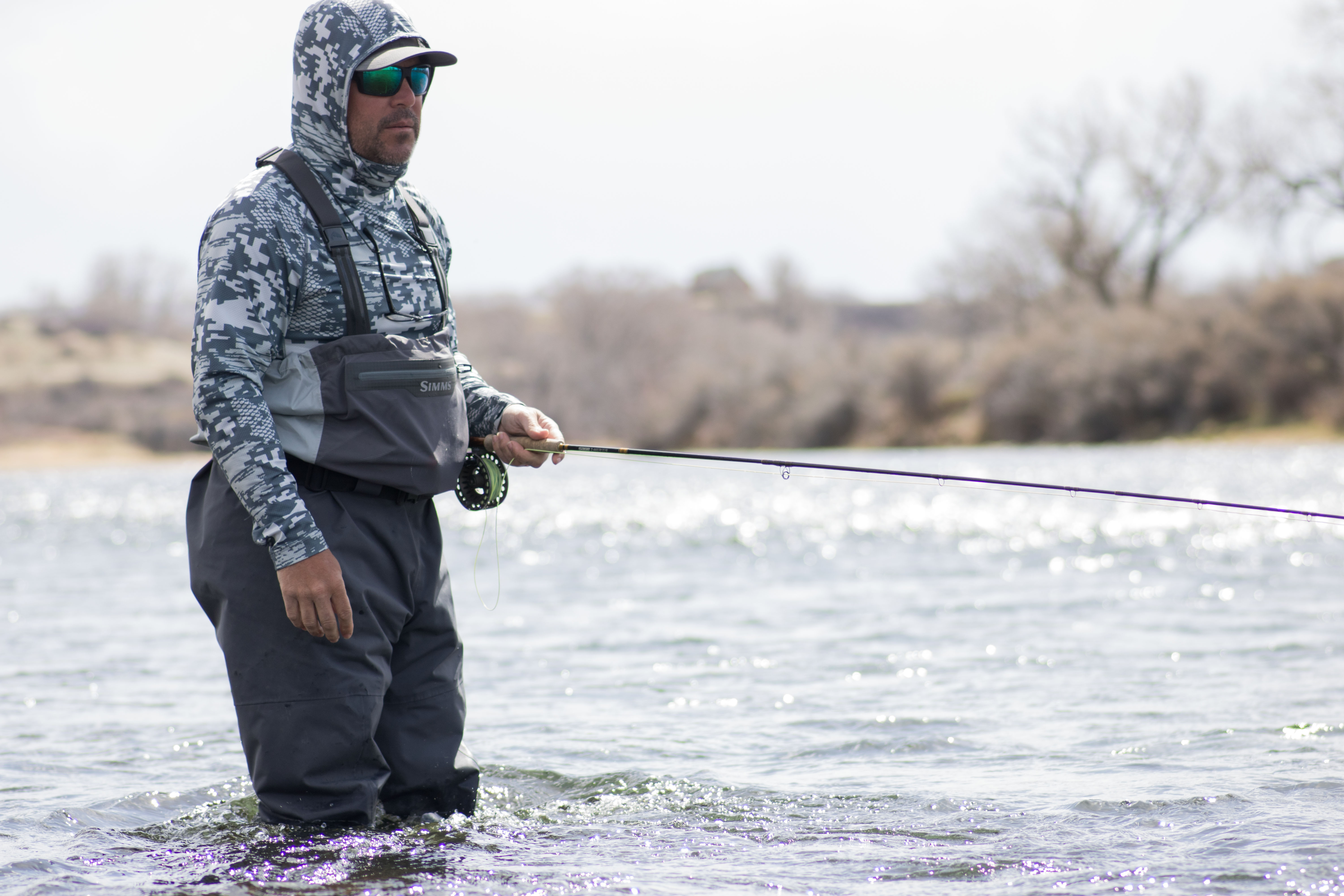 An angler wearing the Simms Flyweight wader while fishing