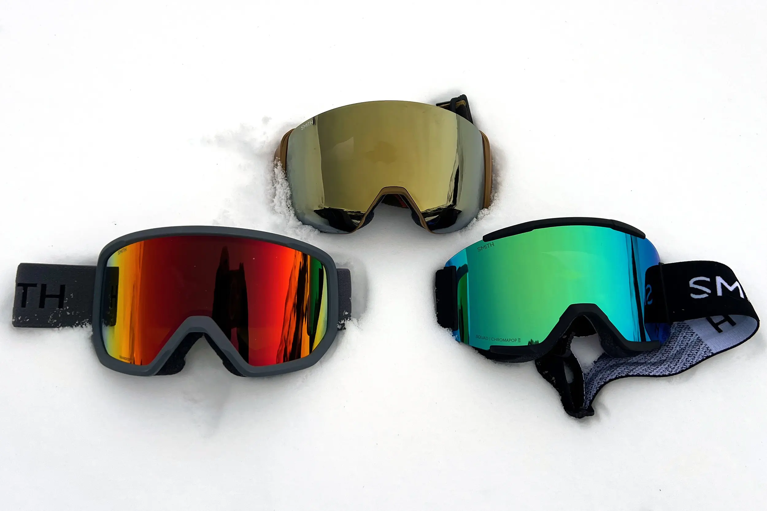Three pairs of Smith snow goggles on snow