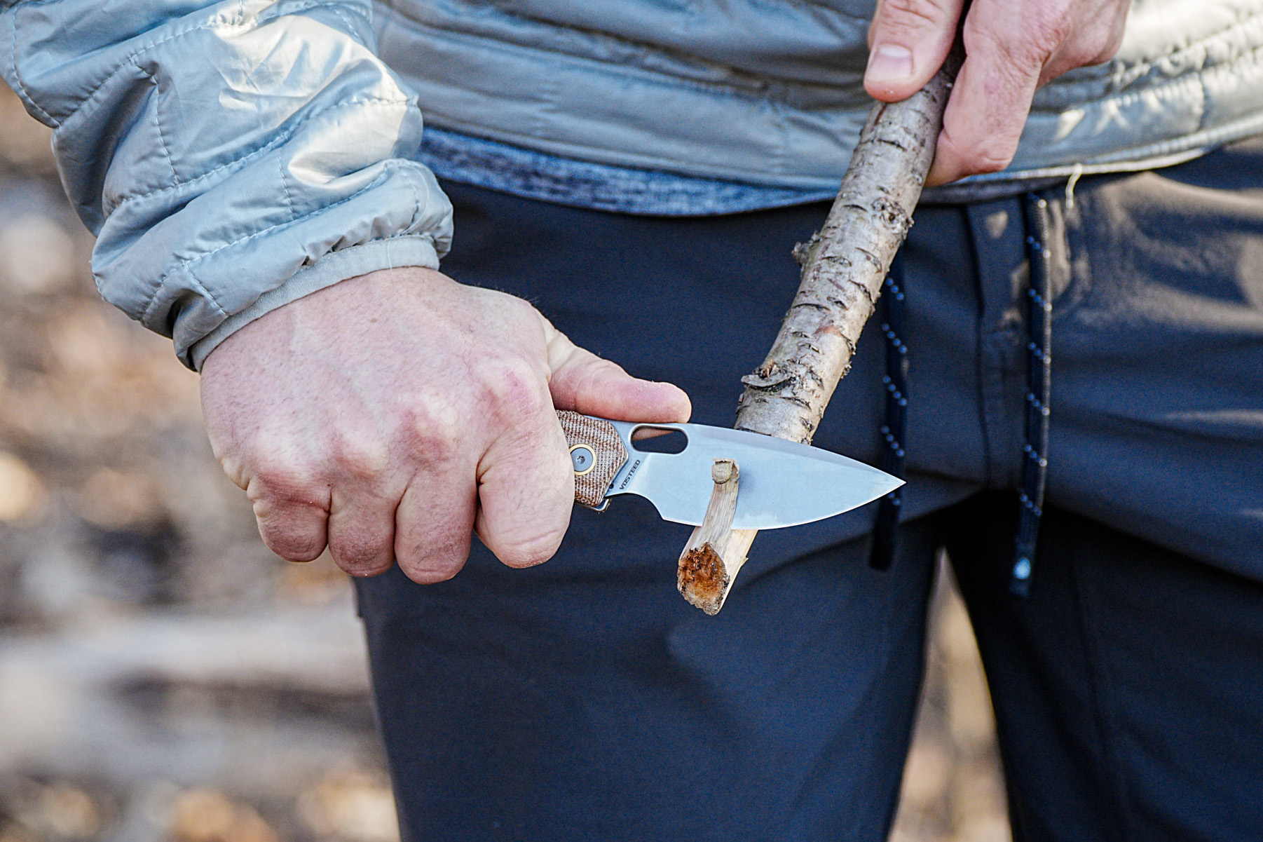 whittling a branch with knife
