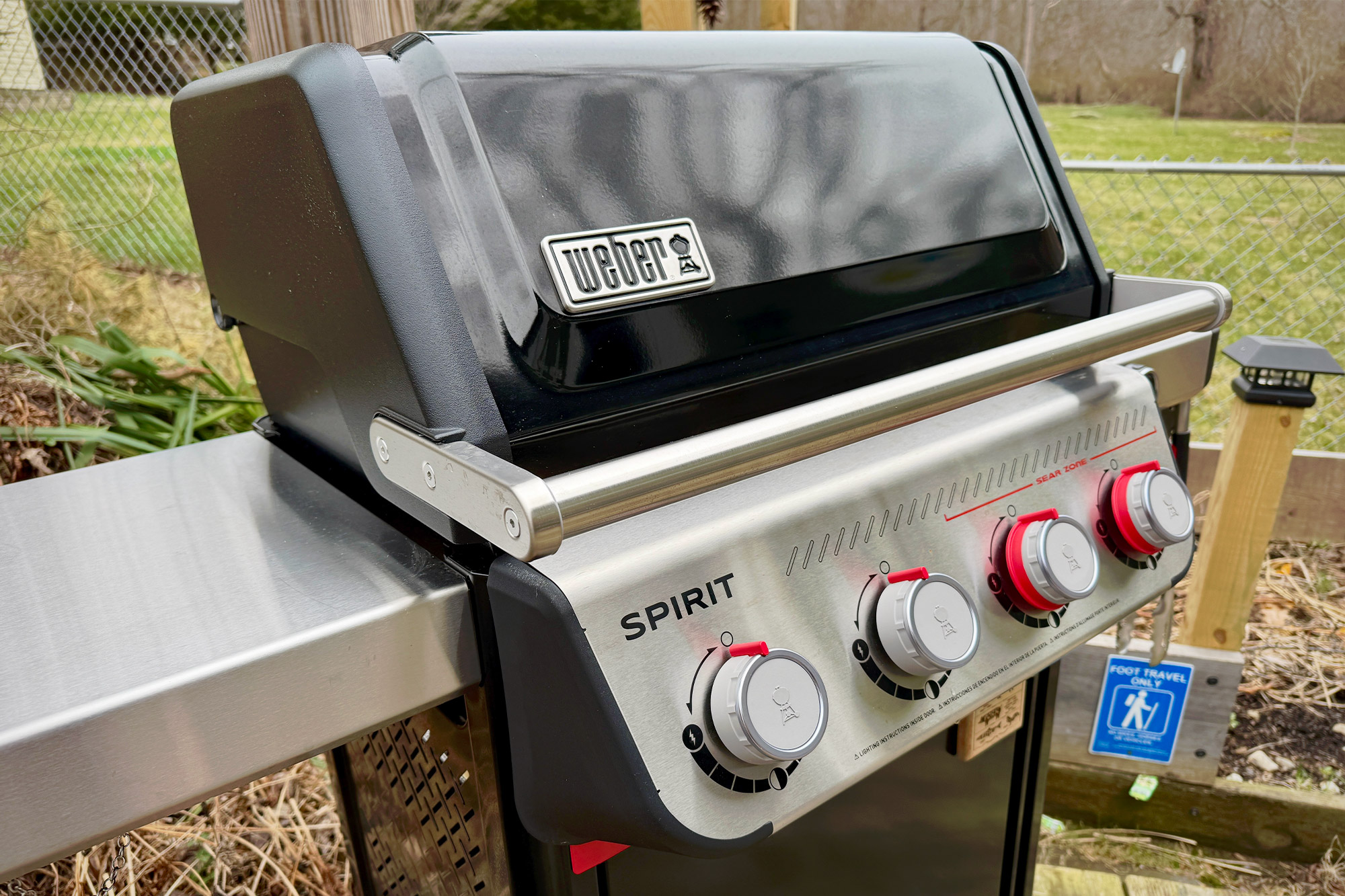 Fully assembled Weber Spirit Propane Grill with four control knobs and closed lid on a patio