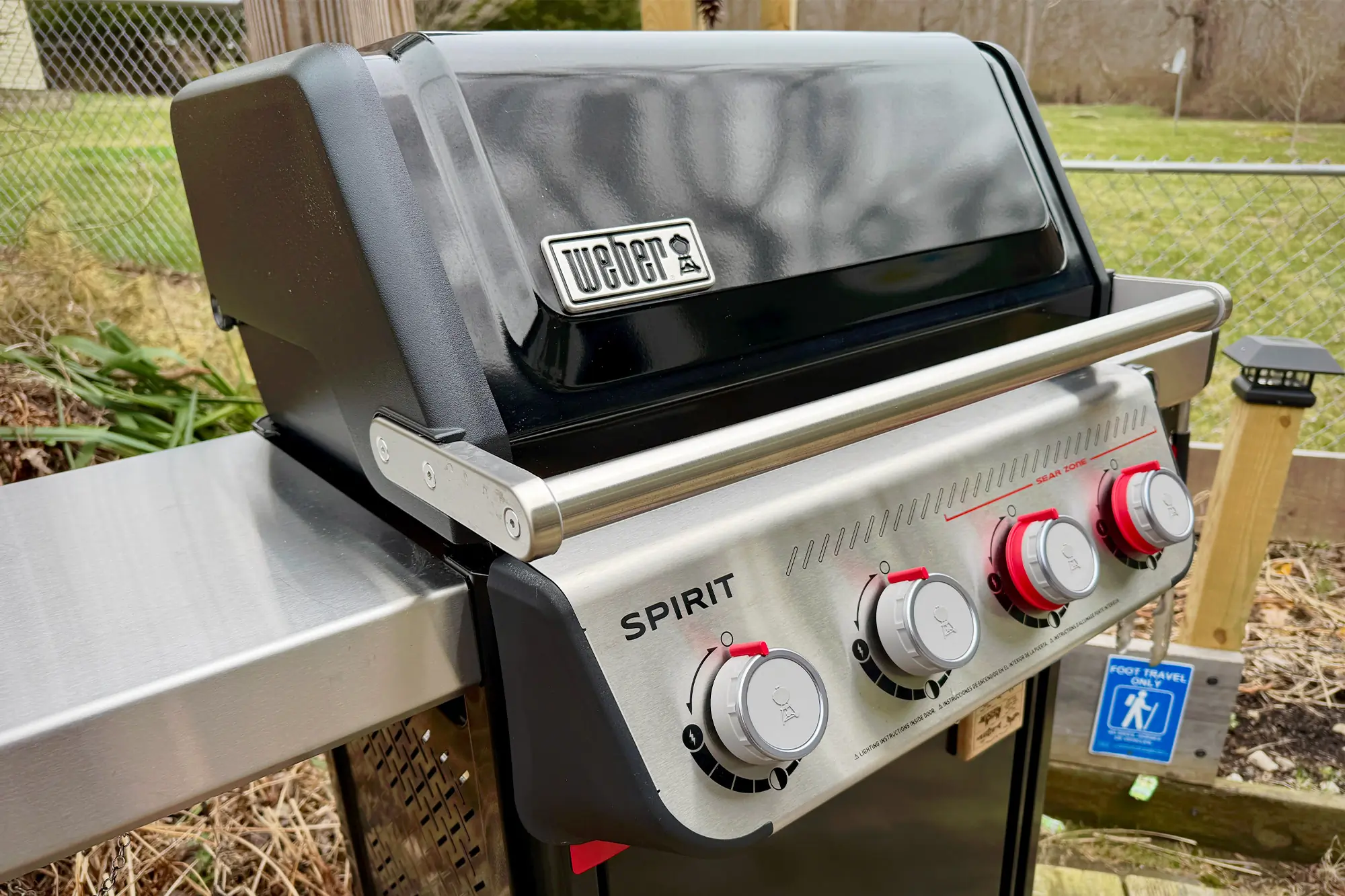 Fully assembled Weber Spirit Propane Grill with four control knobs and closed lid on a patio