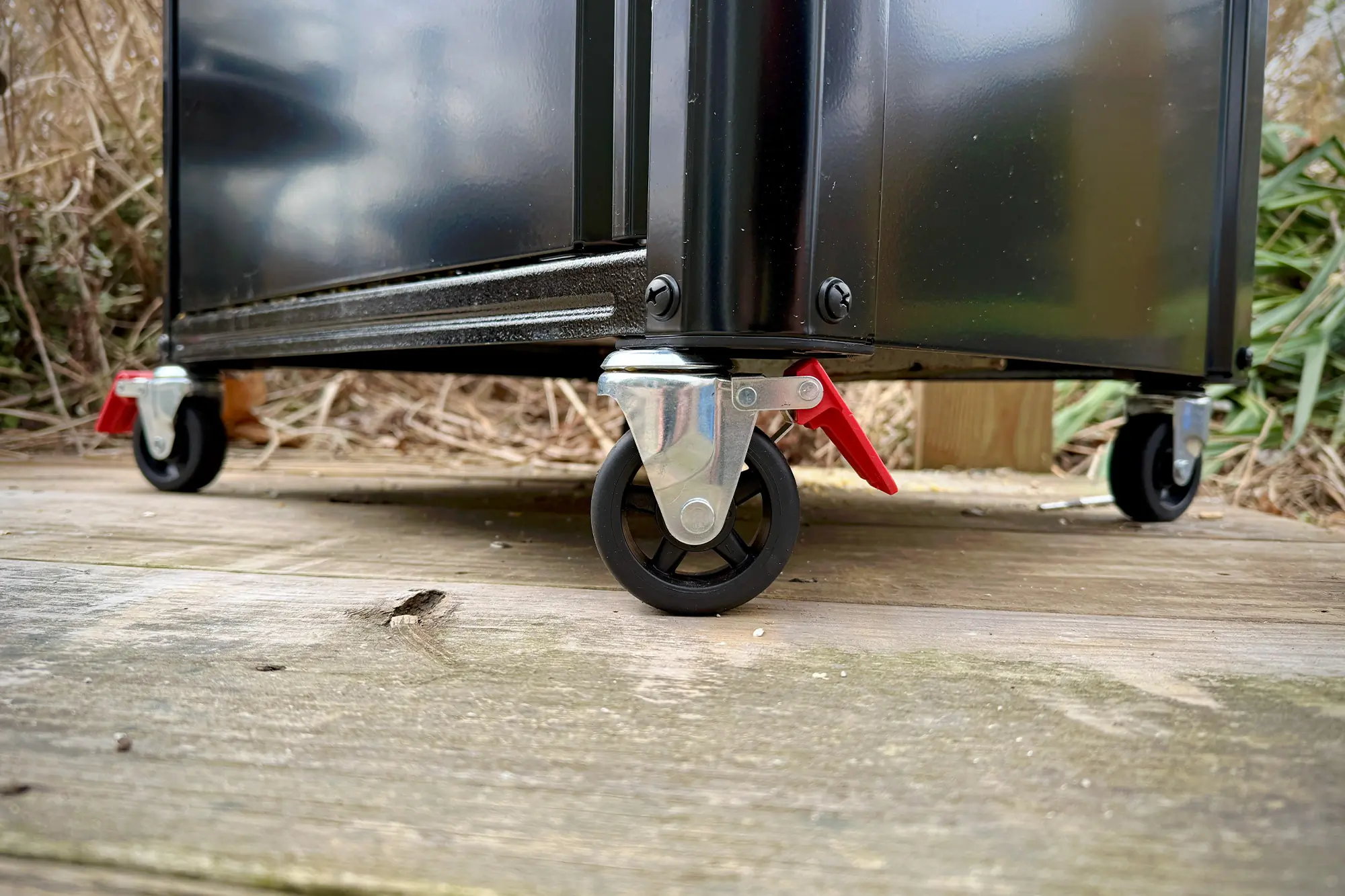 Close-up of the Weber Spirit Propane Grill's black caster wheels with red locking levers