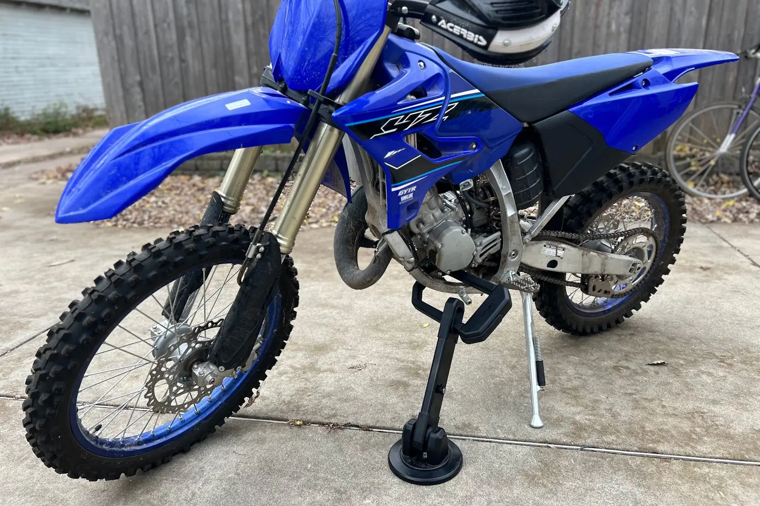 Hiplok DX1000 locking a blue dirt bike on a concrete driveway