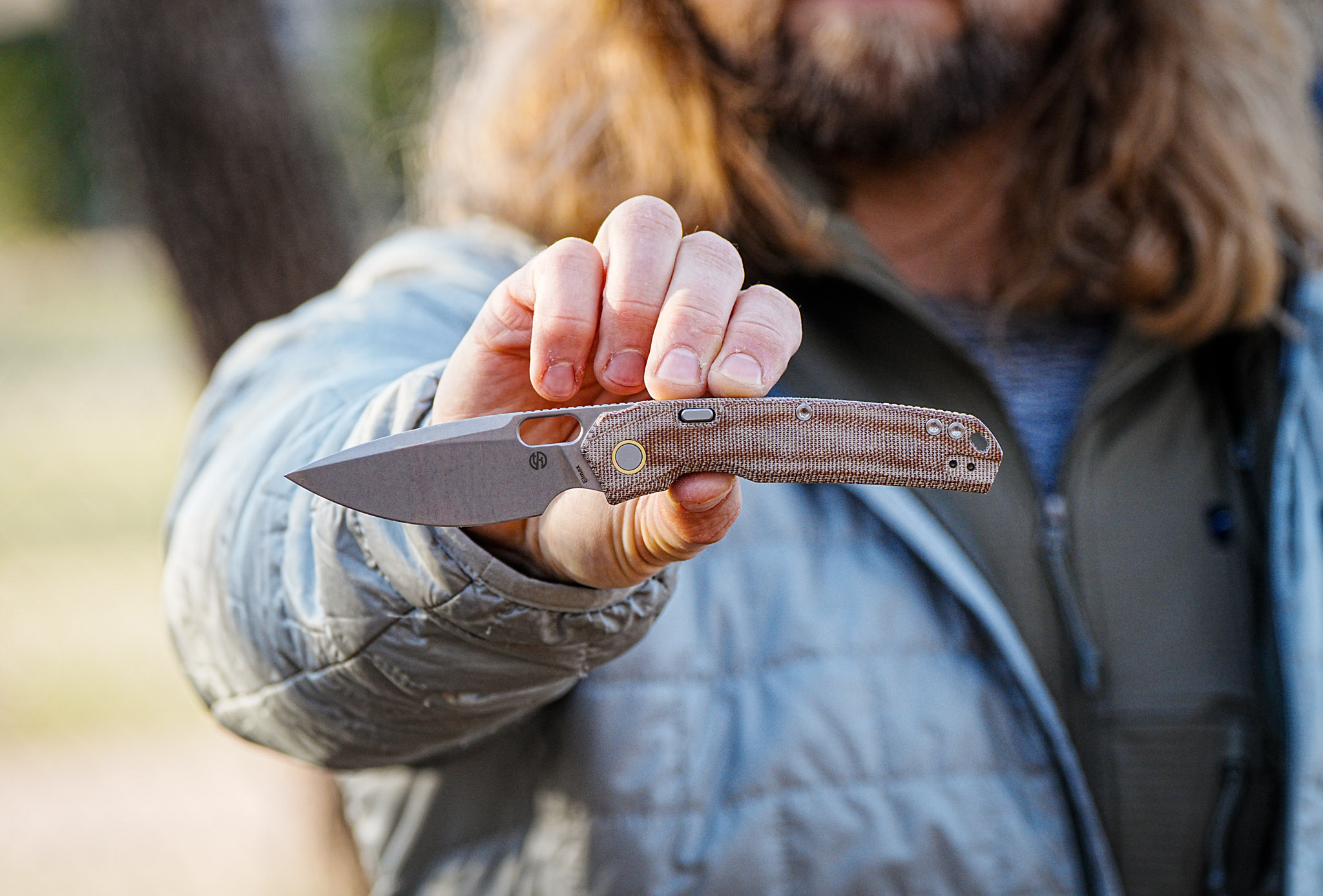 man holding Vosteed knife in front of face