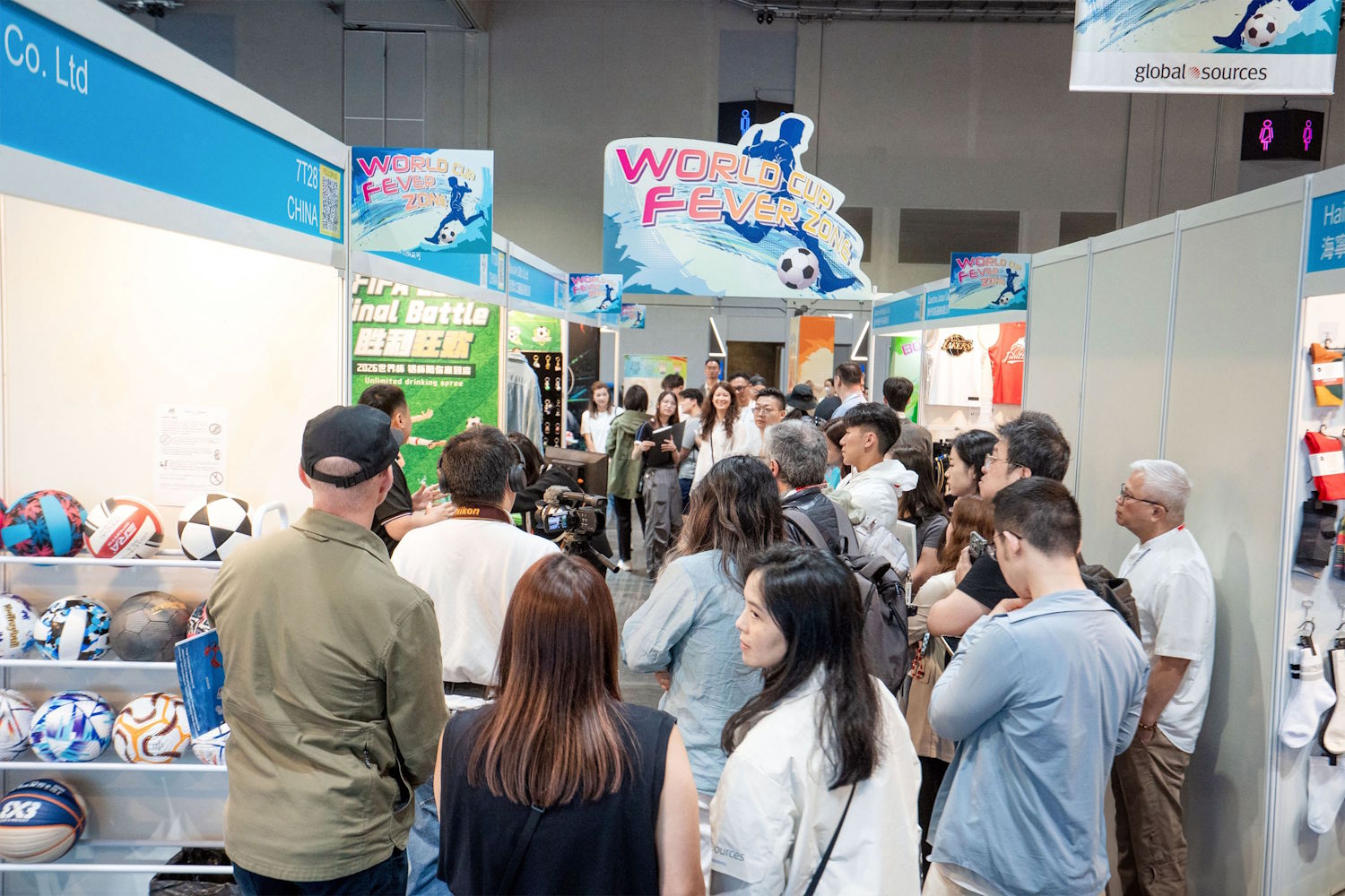 Crowd at a trade show in Hong Kong, viewing sports merchandise and displays.