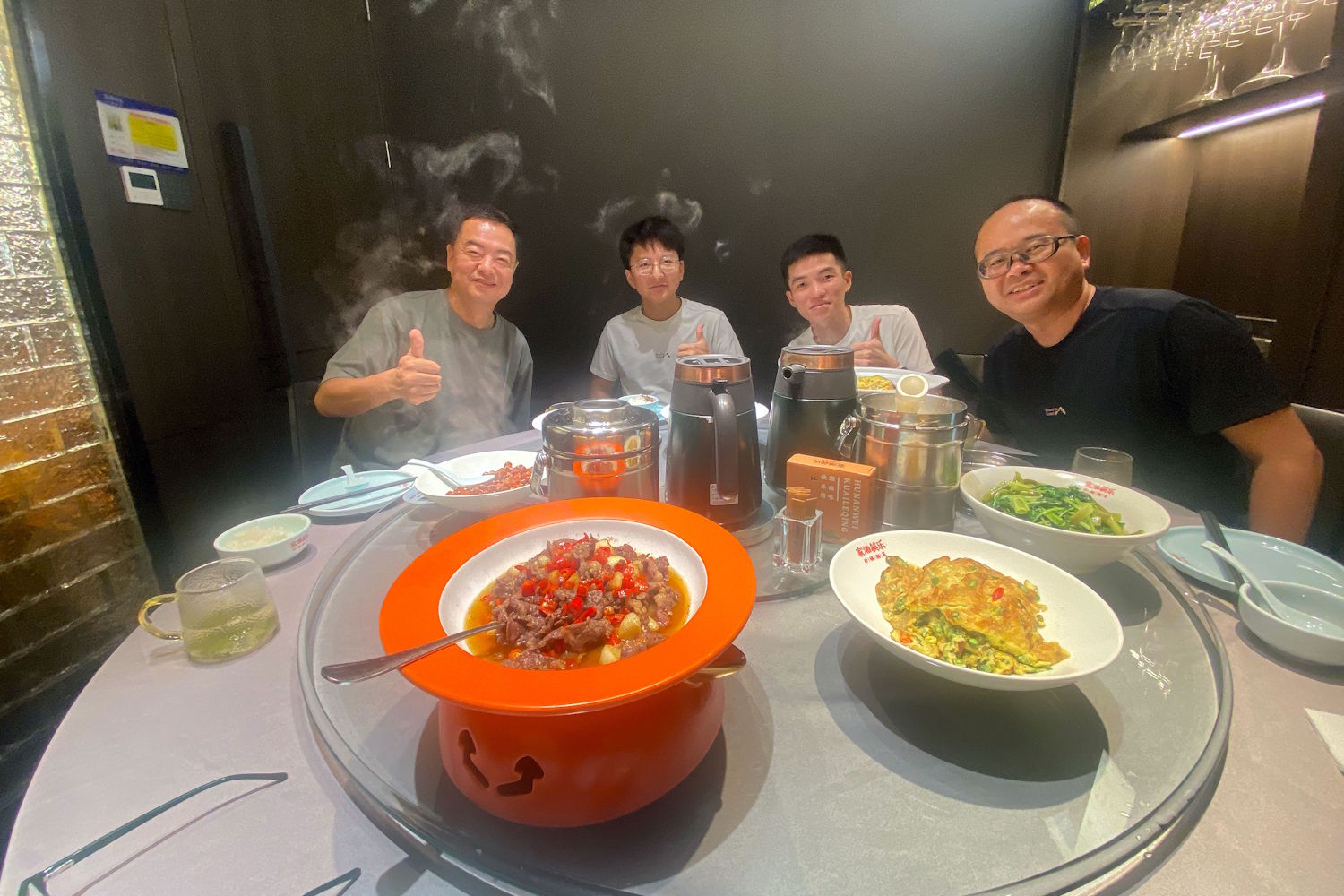 Four men enjoying a Chinese meal around a round table