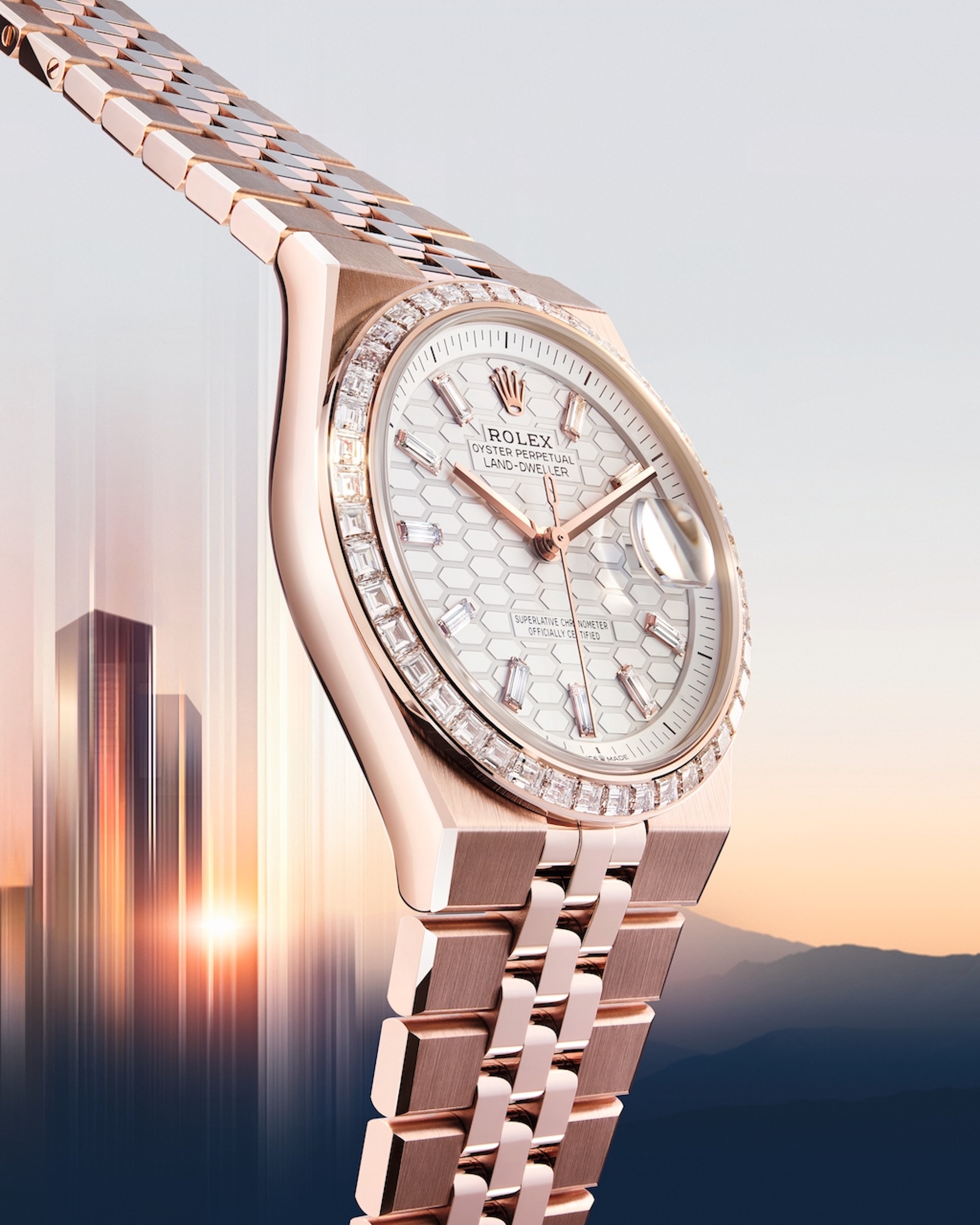 rose gold watch with mountains and skyscraper behind