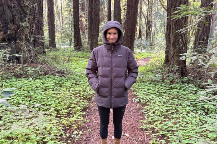 Person wearing a hooded Patagonia puffer jacket on a forest trail
