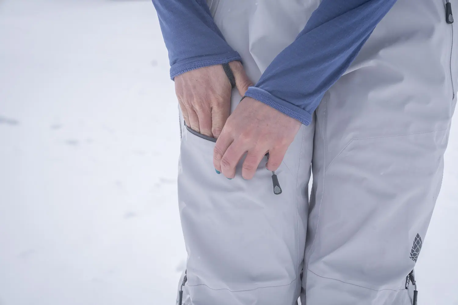 Women placing hand inside stio environ bibs pocket